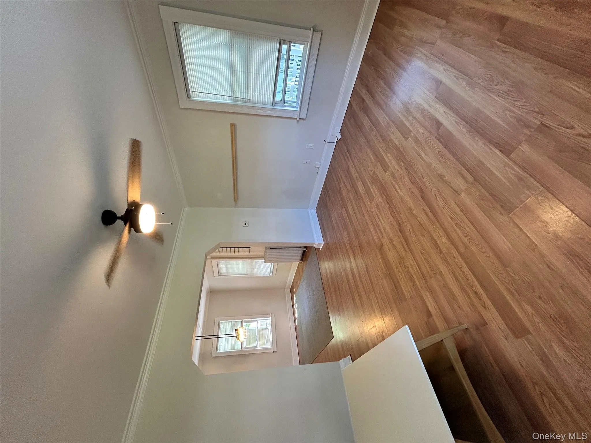 Unfurnished room featuring crown molding, radiator, a ceiling fan, and wood finished floors Unfurnished room featuring crown molding, radiator, a ceiling fan, and wood finished floors