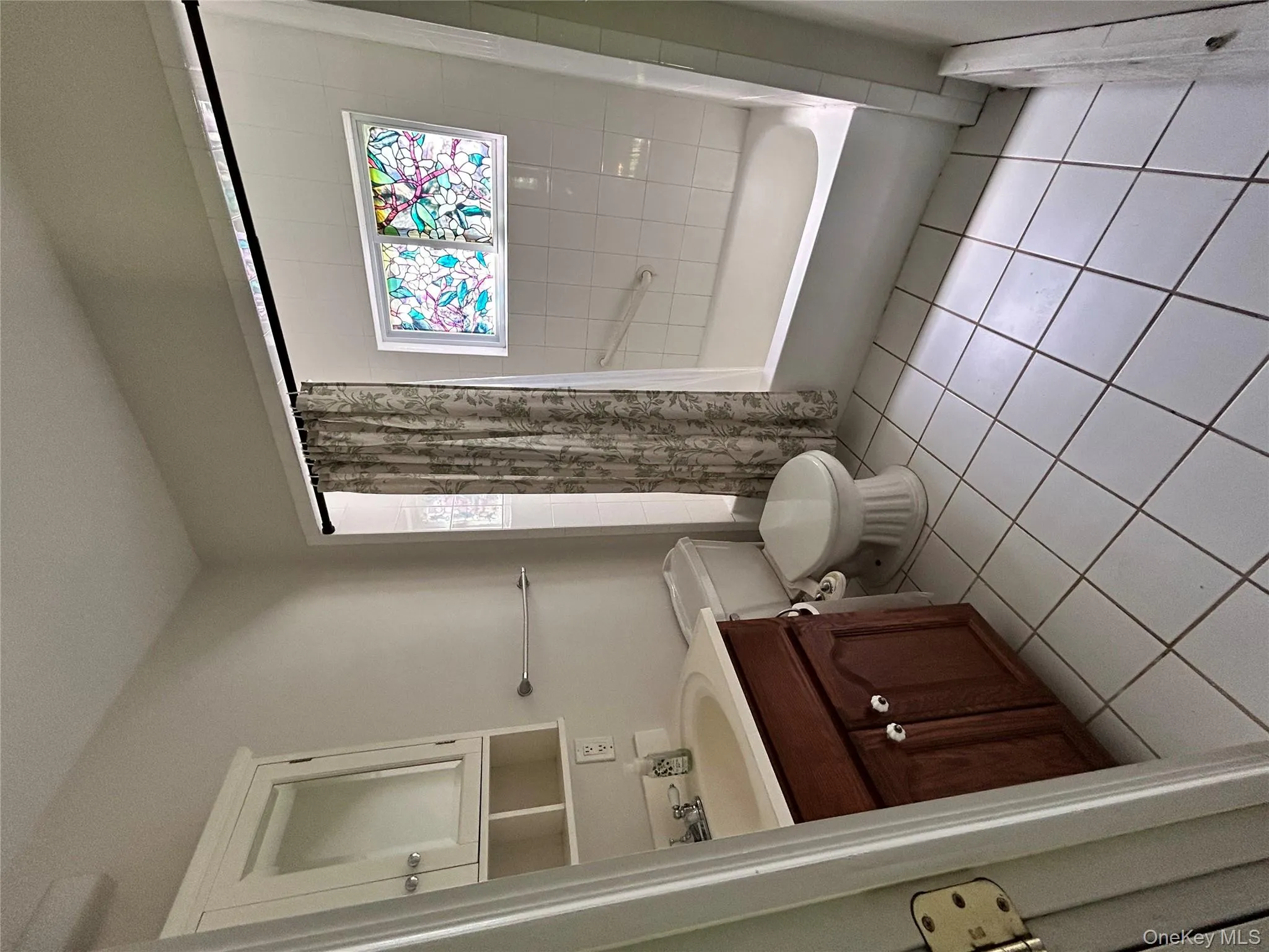 Bathroom with toilet, tile patterned floors, shower / bathtub combination with curtain, and vanity Bathroom with toilet, tile patterned floors, shower / bathtub combination with curtain, and vanity