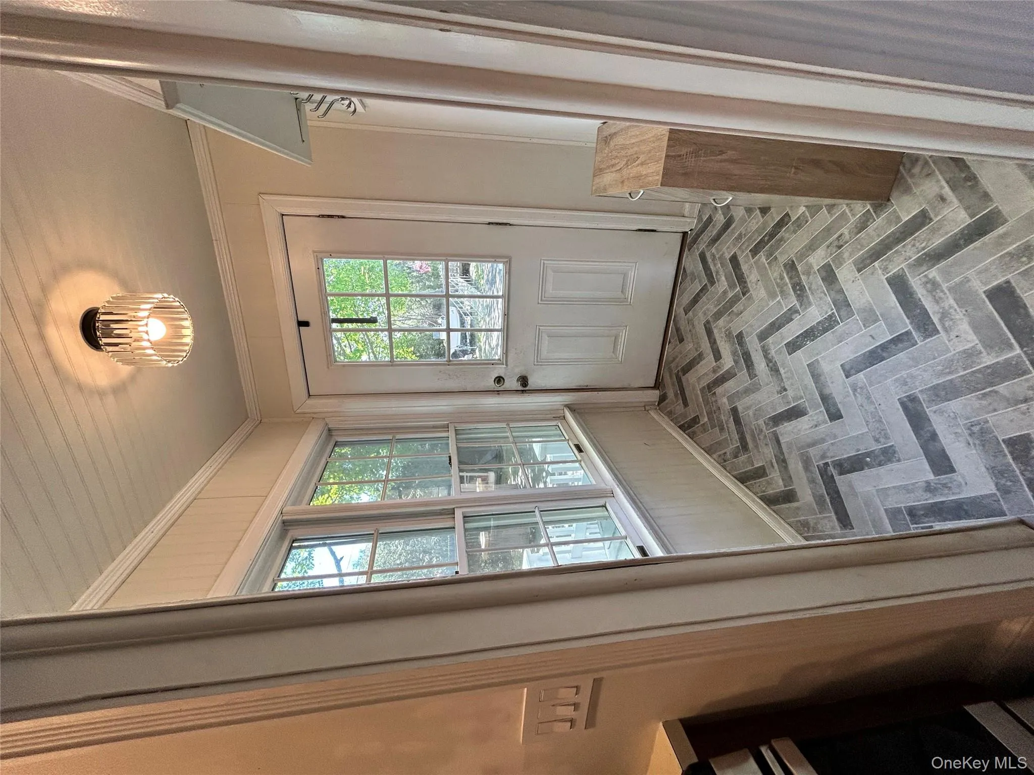 Entryway featuring crown molding, brick floor, and a notable chandelier Entryway featuring crown molding, brick floor, and a notable chandelier