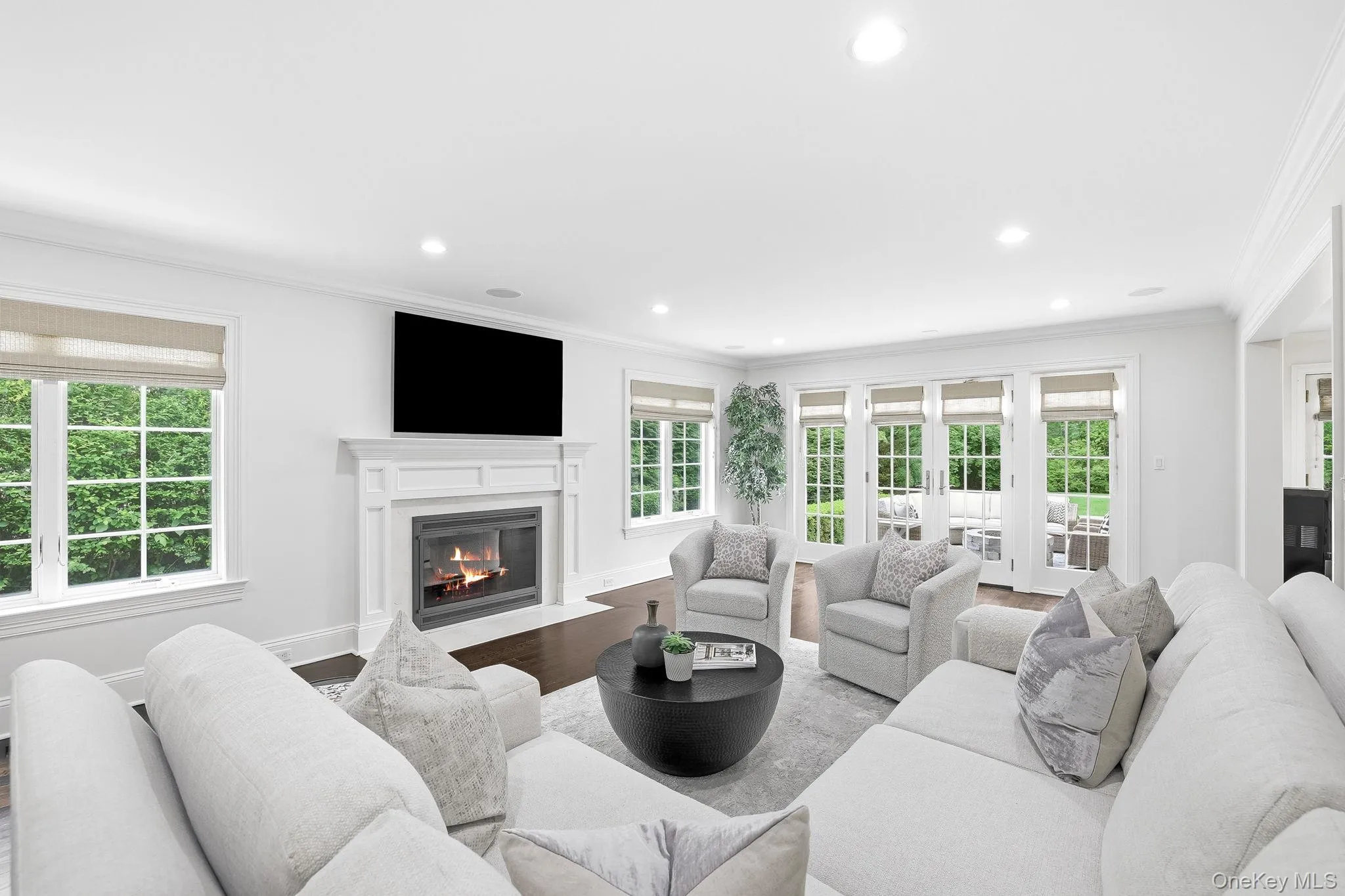 The bright family room is surrounded by windows with French doors accessing the patio and yard. The bright family room is surrounded by windows with French doors accessing the patio and yard.