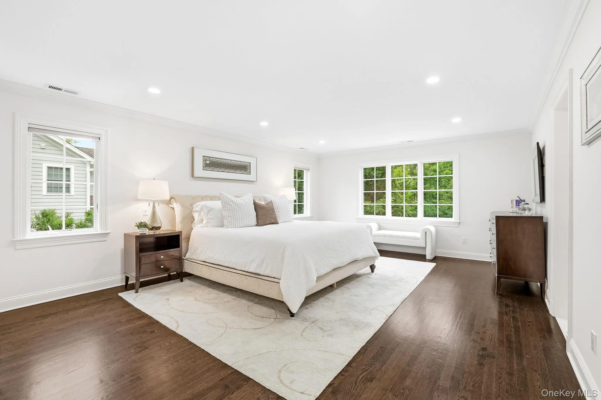 Peaceful primary bedroom suite with two fully outfitted walk-in closets, hardwood floors and multiple exposures overlooking the tranquil yard. Peaceful primary bedroom suite with two fully outfitted walk-in closets, hardwood floors and multiple exposures overlooking the tranquil yard.