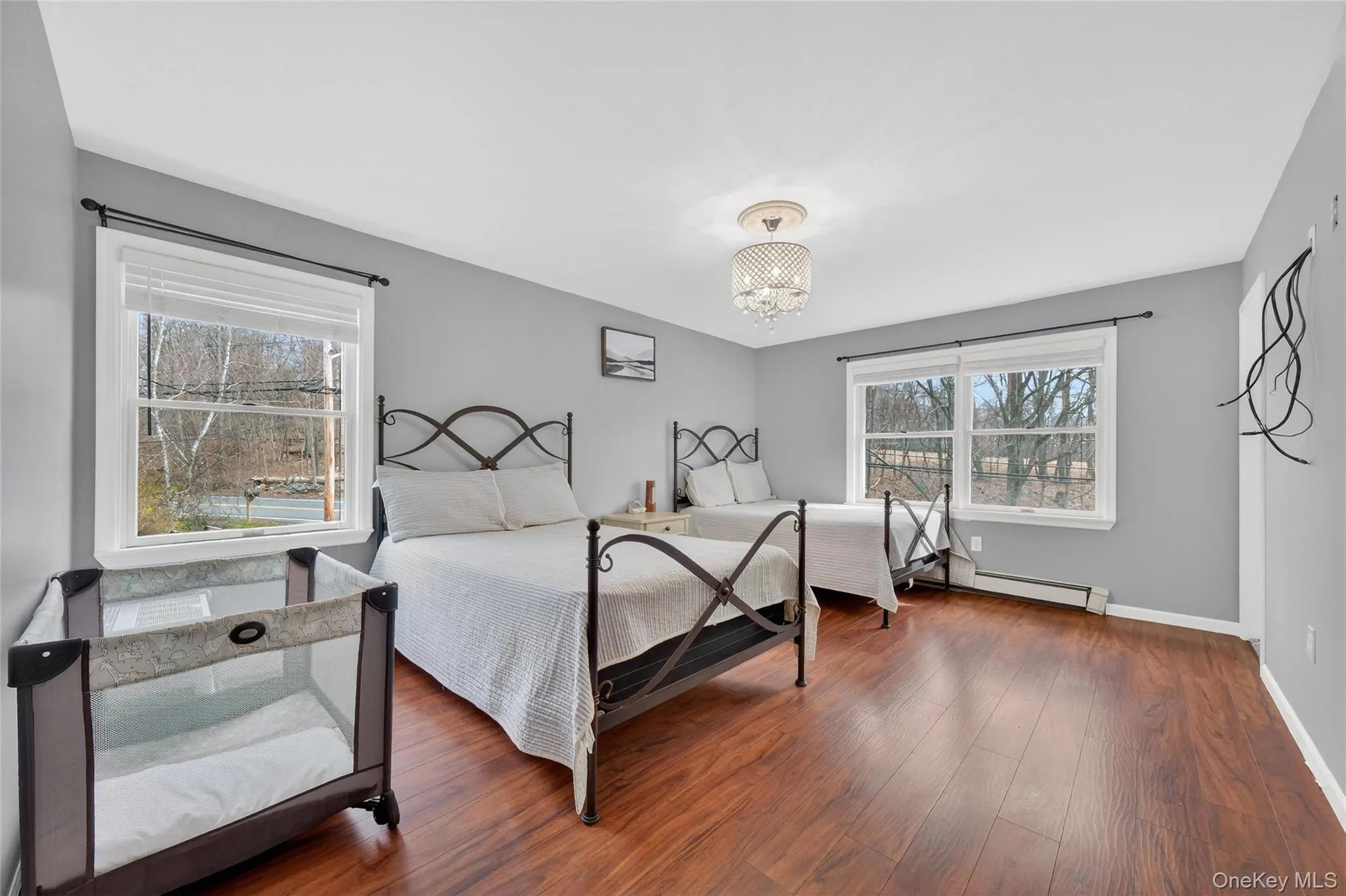 Bedroom with hardwood / wood-style floors and a baseboard heating unit Bedroom with hardwood / wood-style floors and a baseboard heating unit