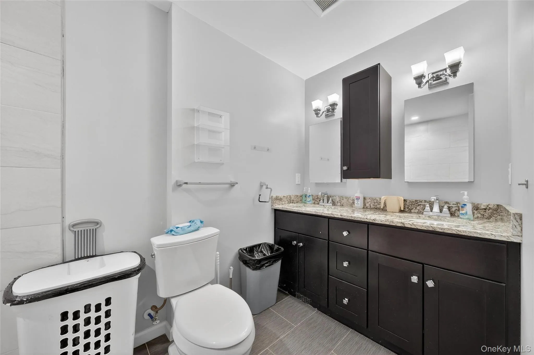 Bathroom featuring toilet and double vanity Bathroom featuring toilet and double vanity