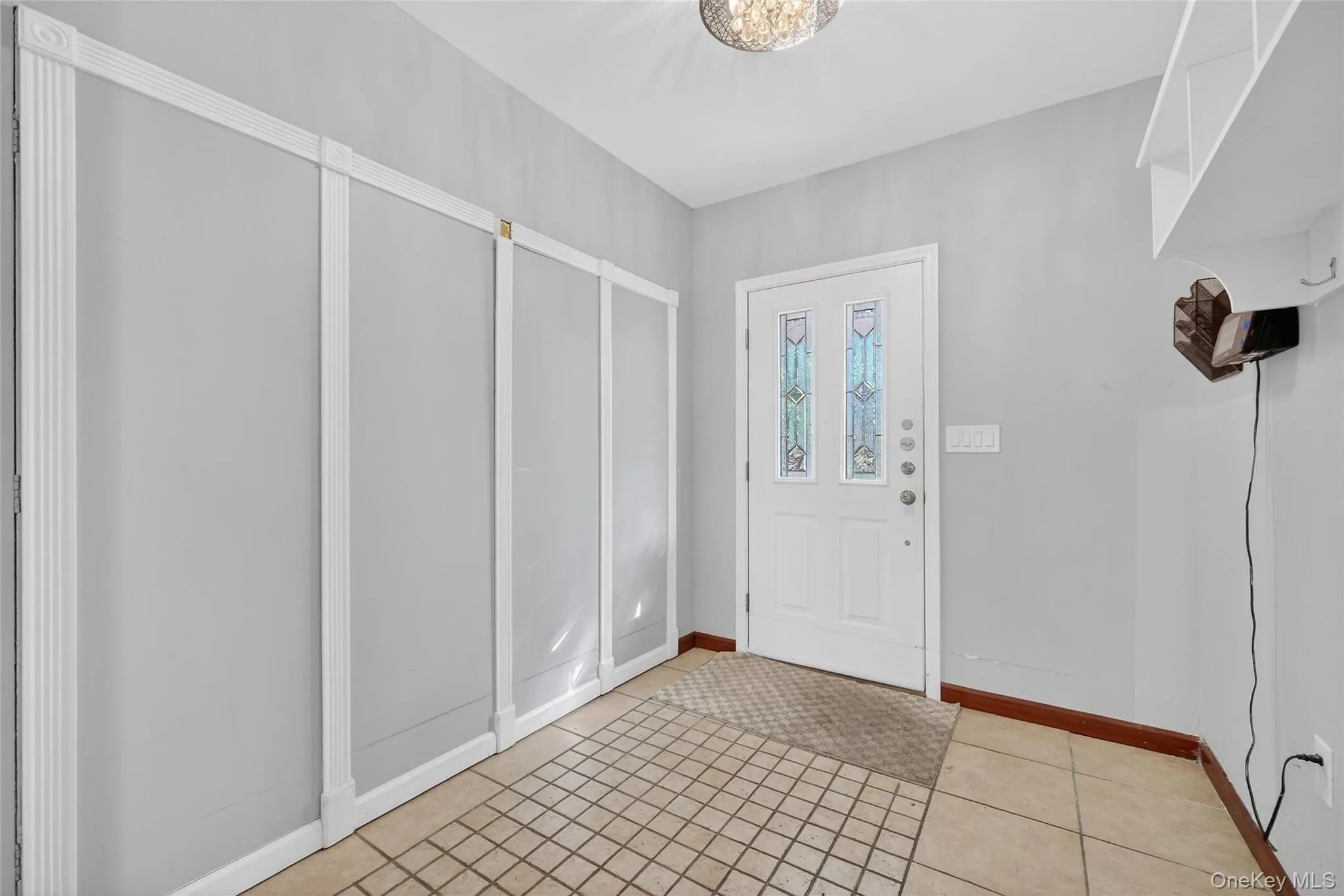 Foyer entrance featuring baseboards and light tile patterned flooring Foyer entrance featuring baseboards and light tile patterned flooring