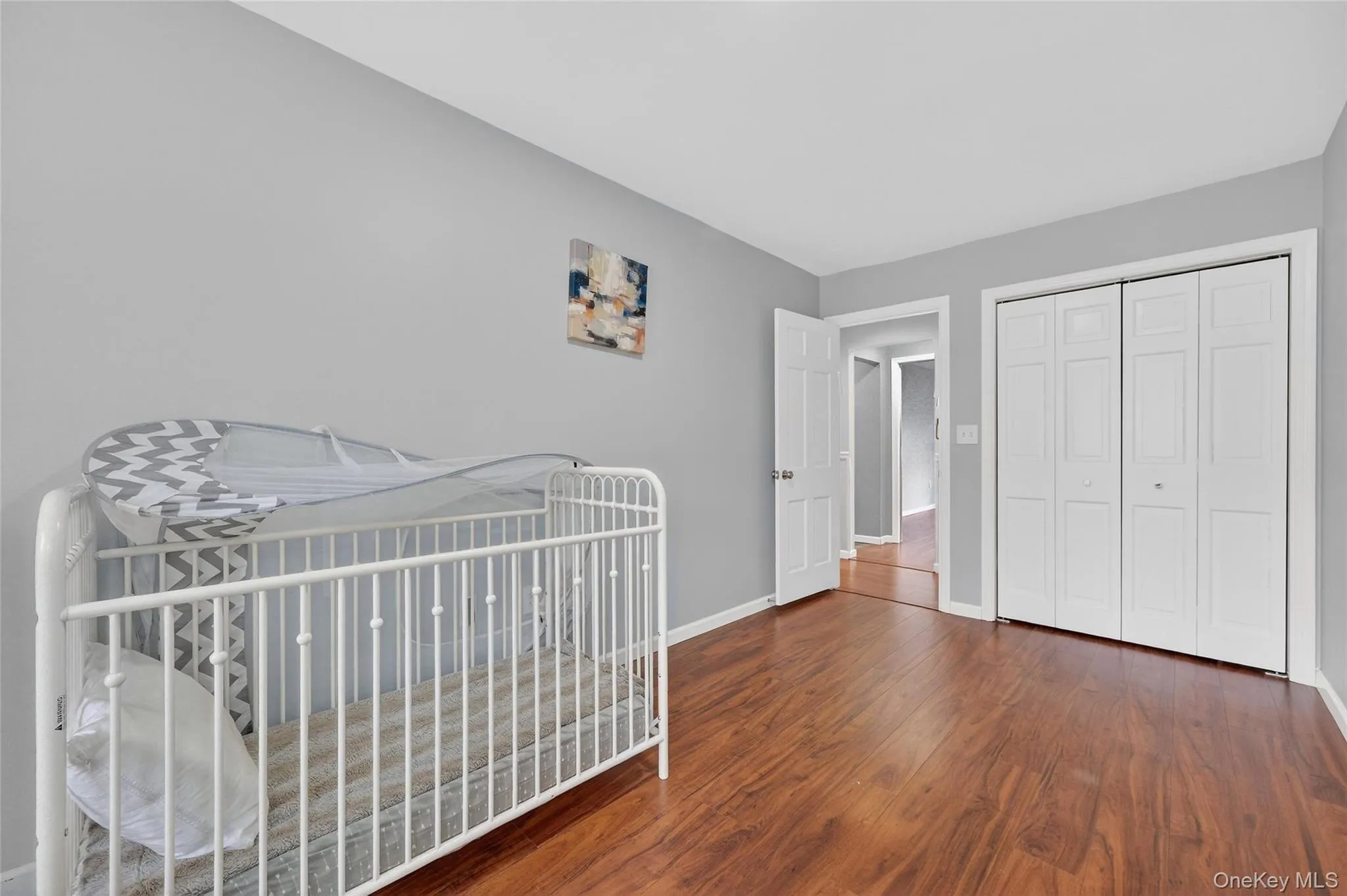Bedroom with dark wood-type flooring and a closet Bedroom with dark wood-type flooring and a closet