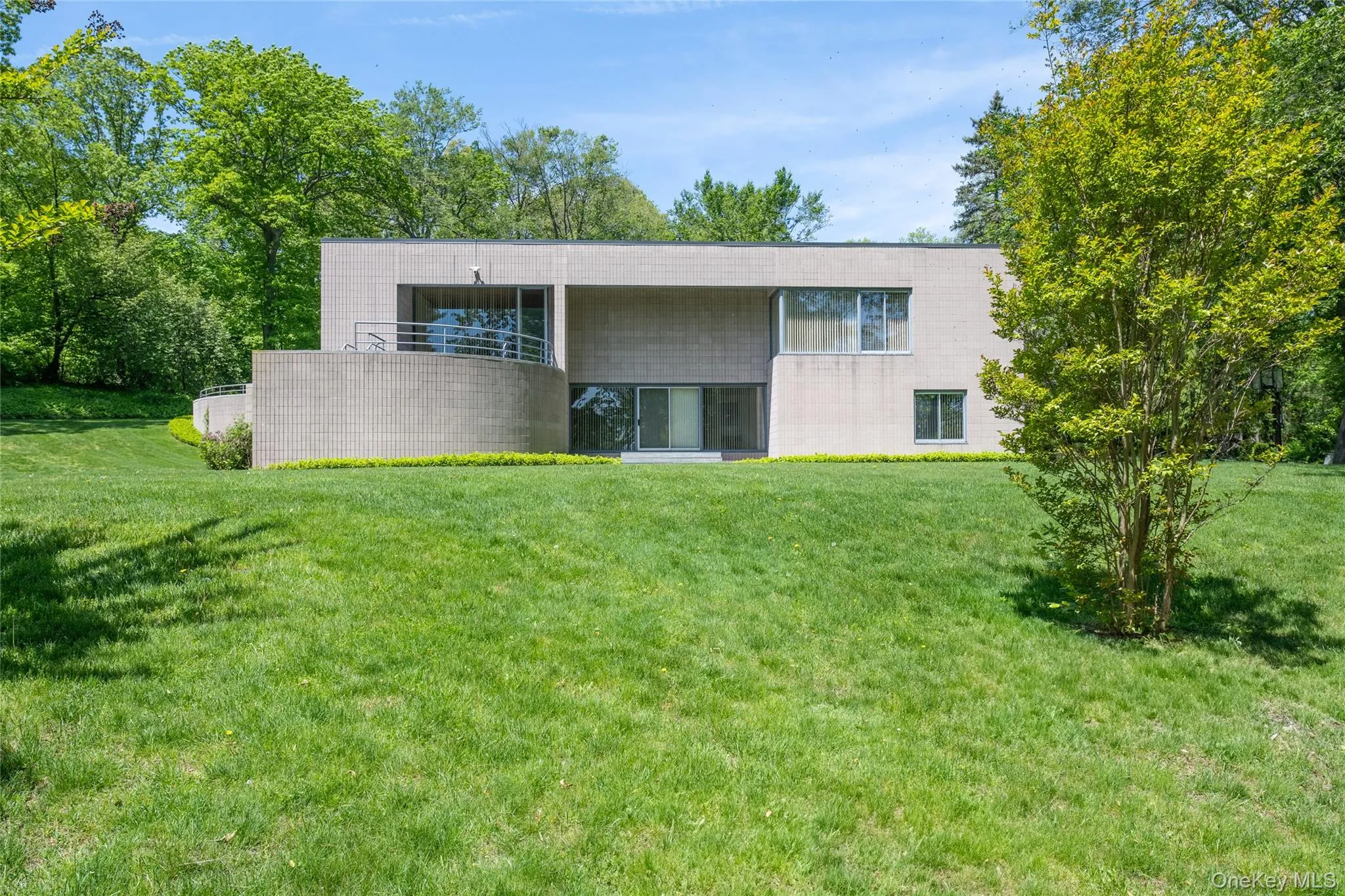 Back of house featuring a lawn and concrete block siding Back of house featuring a lawn and concrete block siding