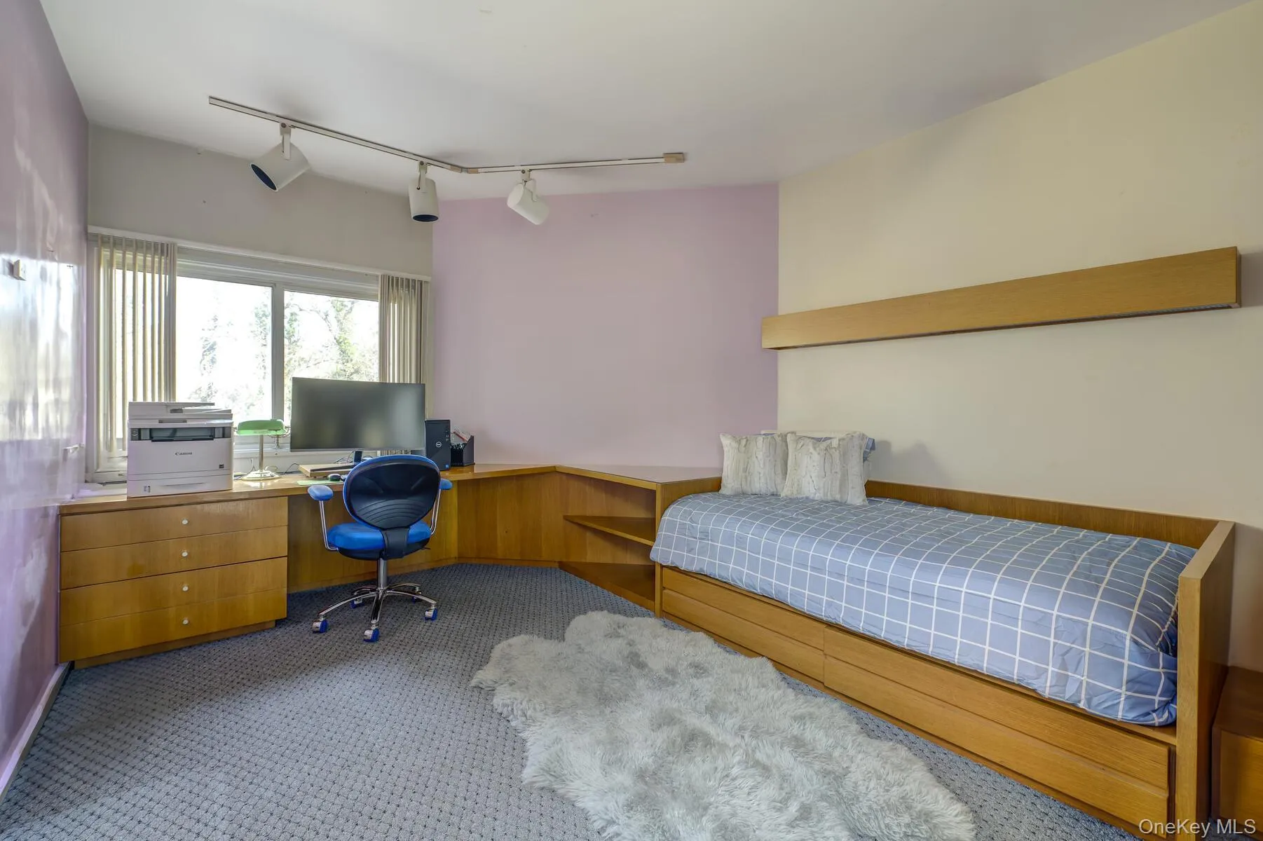 Bedroom featuring light carpet and track lighting Bedroom featuring light carpet and track lighting