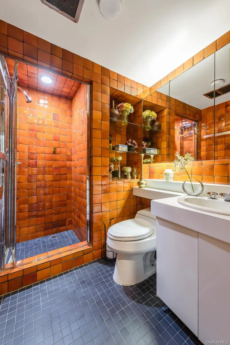 Bathroom featuring tile patterned flooring, vanity, an enclosed shower, and toilet Bathroom featuring tile patterned flooring, vanity, an enclosed shower, and toilet