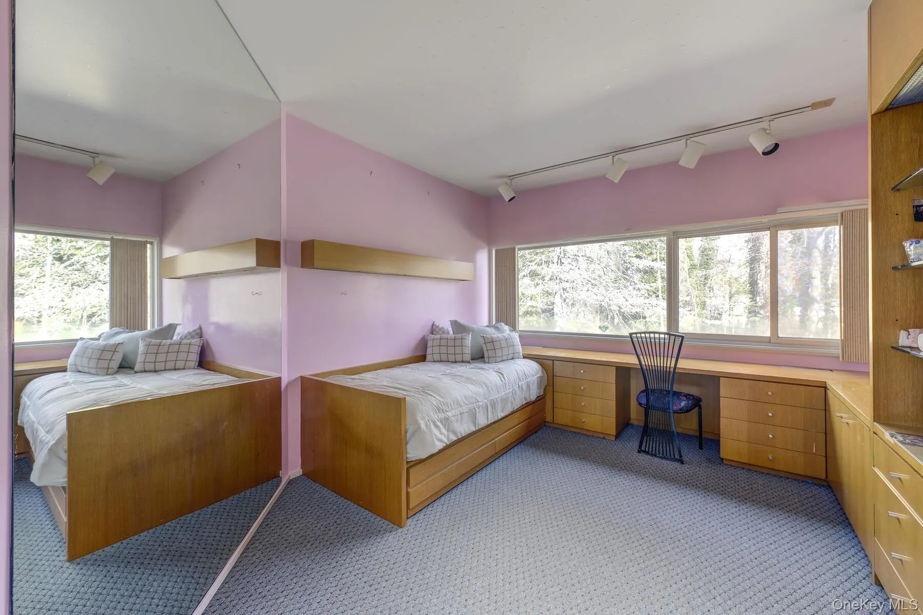 Bedroom featuring light colored carpet, built in desk, and track lighting Bedroom featuring light colored carpet, built in desk, and track lighting