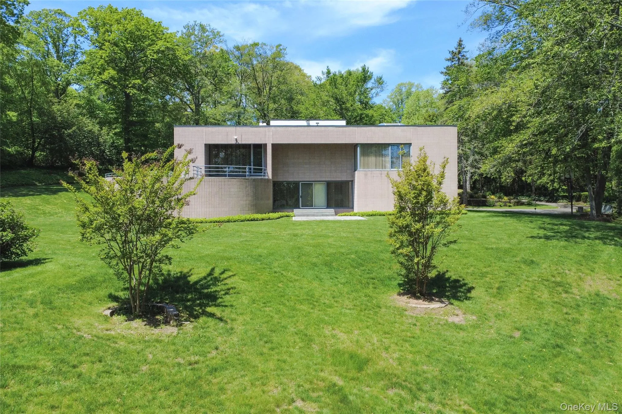 Back of house featuring concrete block siding and a yard Back of house featuring concrete block siding and a yard