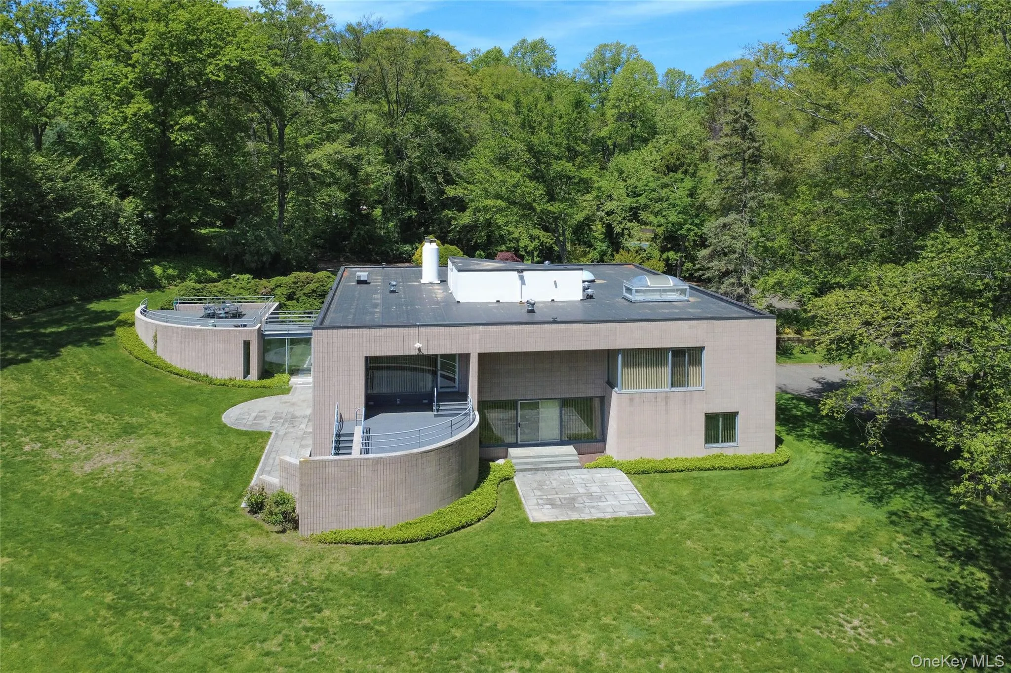 Back of property featuring a lawn, a forest view, and a patio Back of property featuring a lawn, a forest view, and a patio