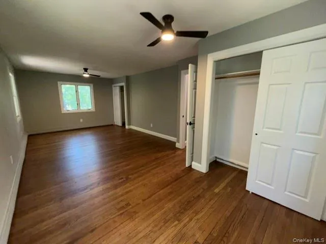 Interior room featuring wood-finish flooring, light gray wall paint, and white trim Interior room featuring wood-finish flooring, light gray wall paint, and white trim