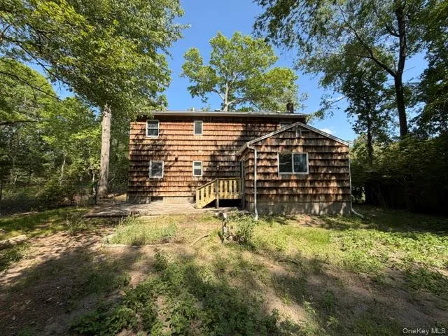 Cedar shake siding exterior with white-trimmed windows and a wooden staircase Cedar shake siding exterior with white-trimmed windows and a wooden staircase