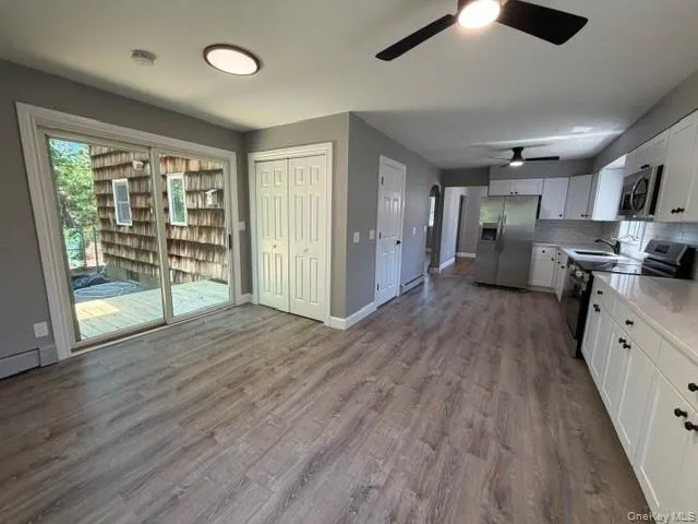 Open concept living area with wood-finish flooring Open concept living area with wood-finish flooring