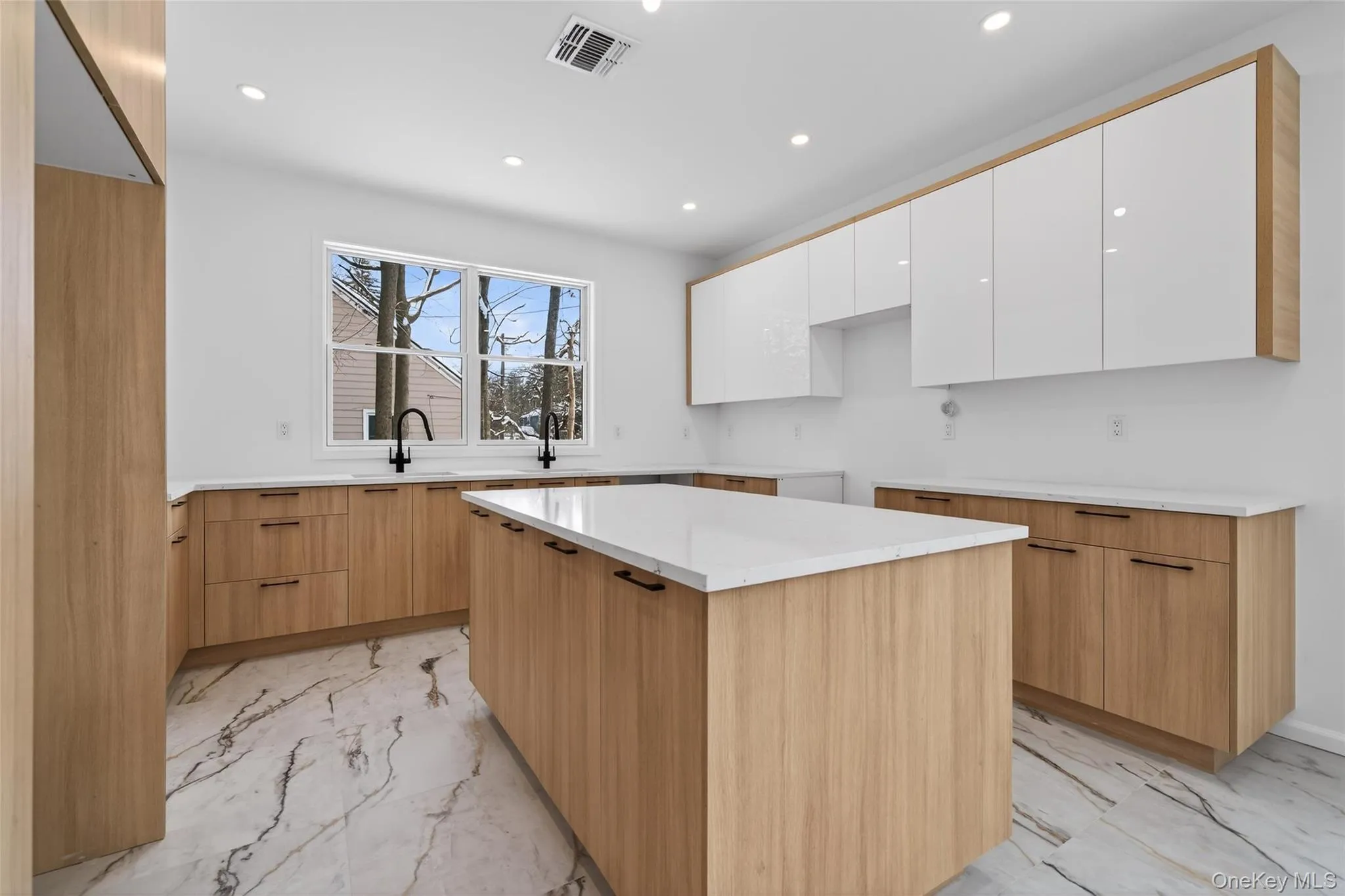 Kitchen with light marble finish flooring, white cabinetry, recessed lighting, modern cabinets, and a center island Kitchen with light marble finish flooring, white cabinetry, recessed lighting, modern cabinets, and a center island
