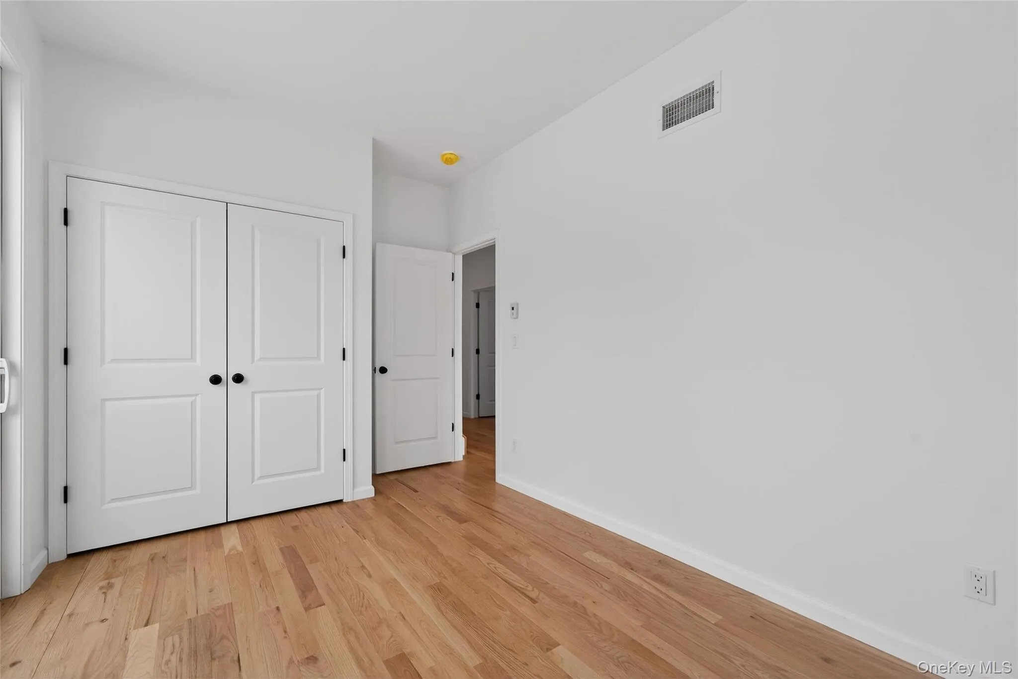 Unfurnished bedroom with light wood-style flooring and a closet Unfurnished bedroom with light wood-style flooring and a closet
