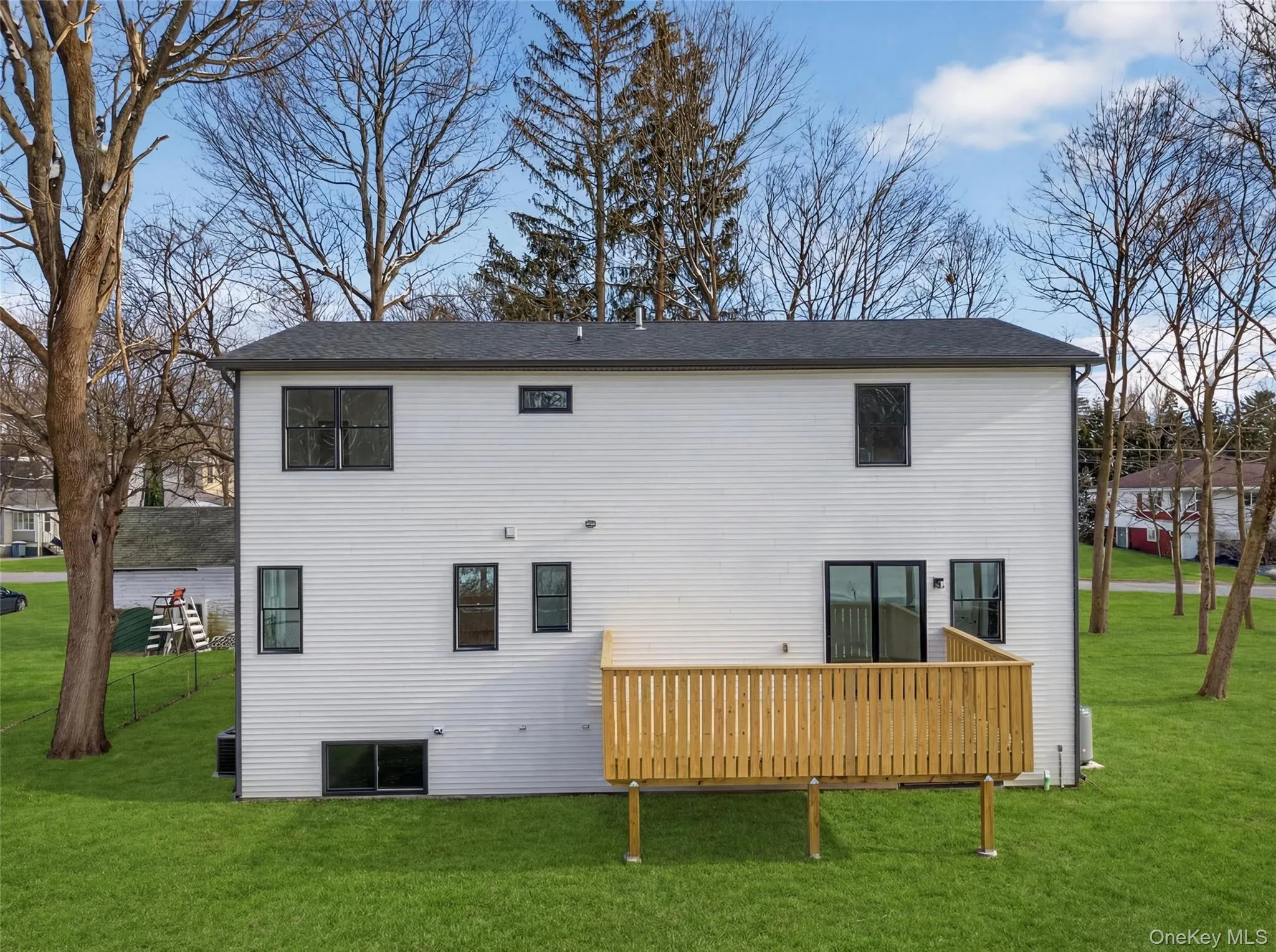 Rear view of house with a yard and a deck Rear view of house with a yard and a deck