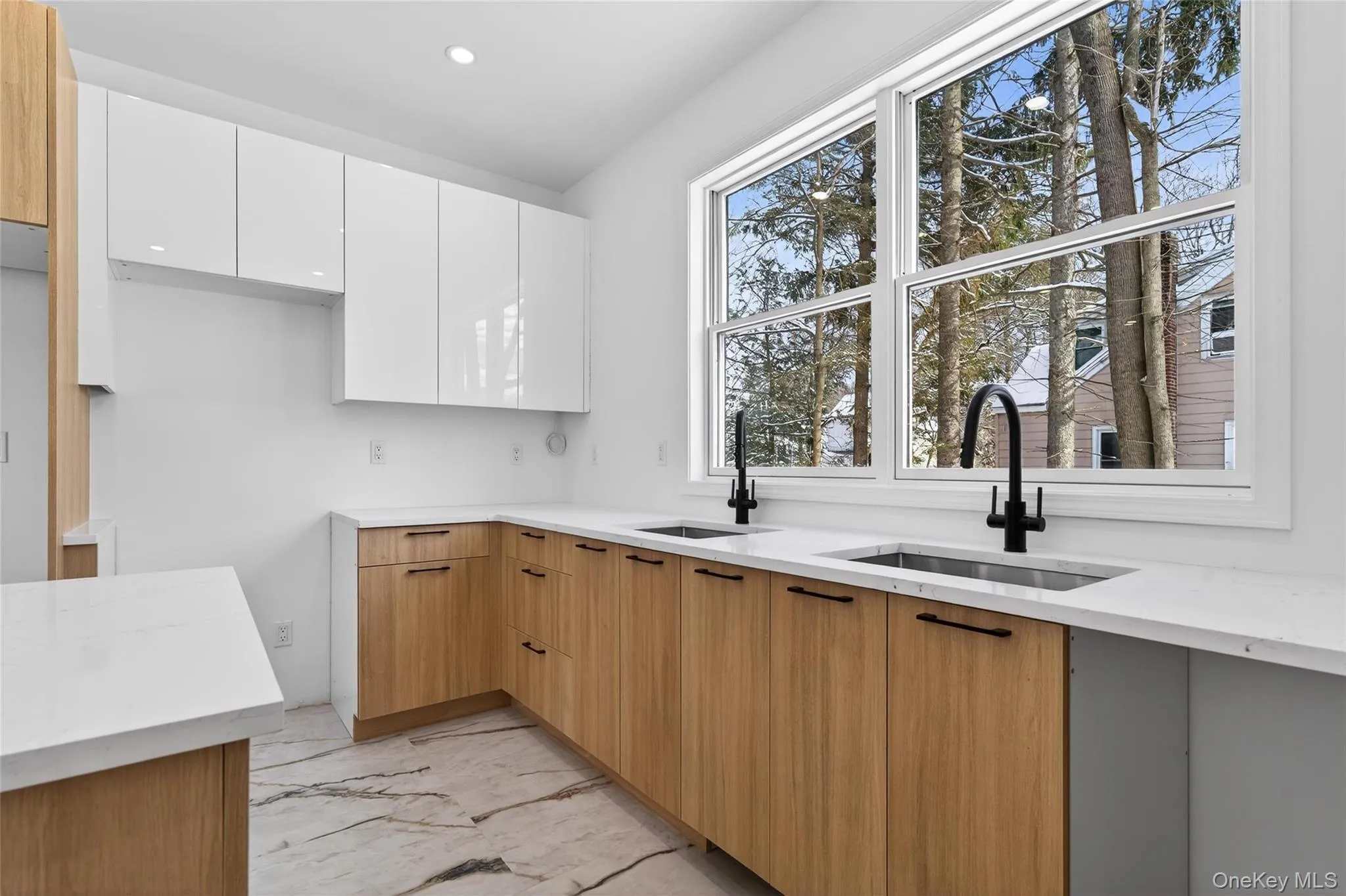 Kitchen with modern cabinets, light marble finish floors, white cabinets, light stone countertops, and recessed lighting Kitchen with modern cabinets, light marble finish floors, white cabinets, light stone countertops, and recessed lighting