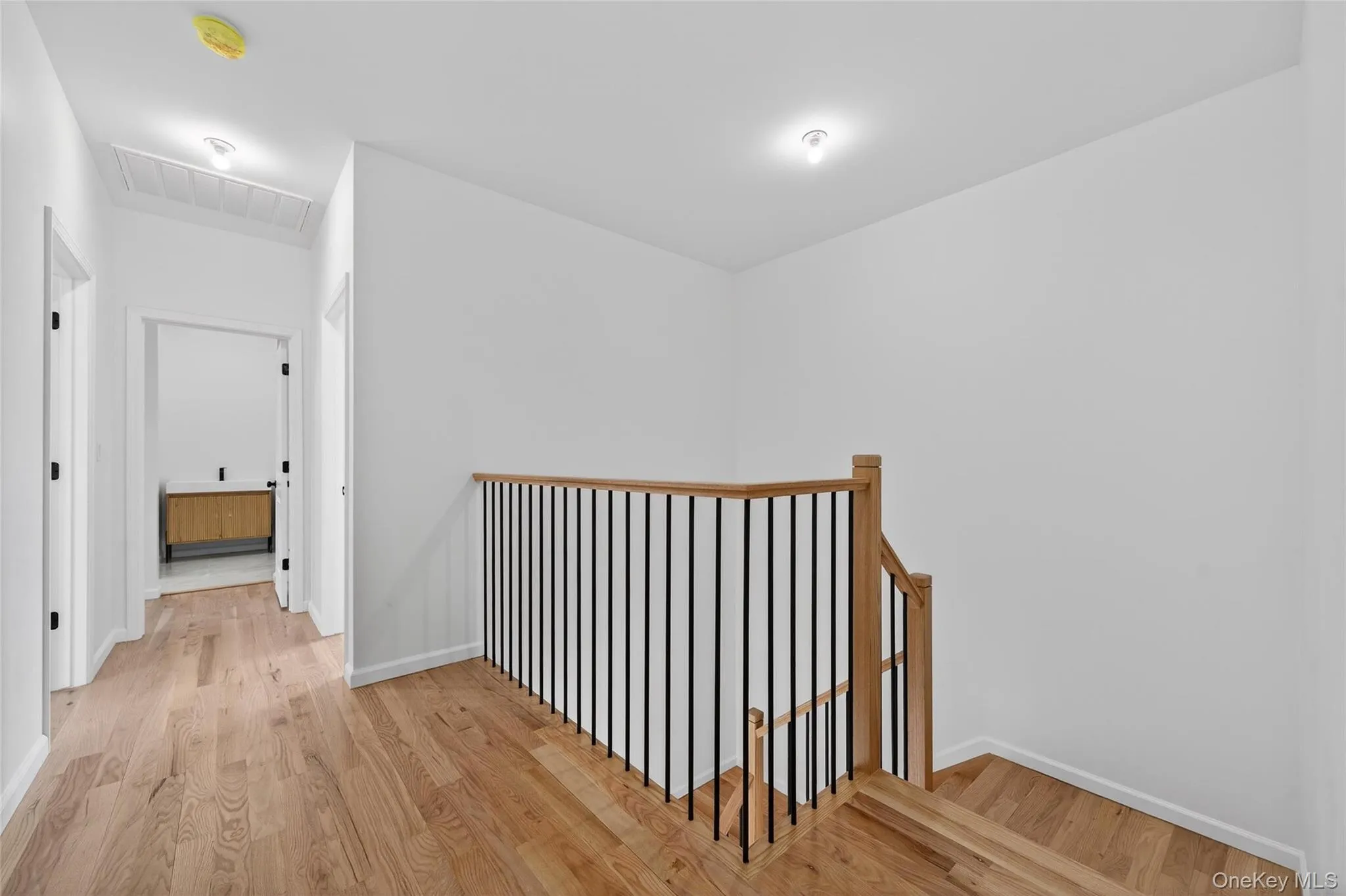 Hallway featuring an upstairs landing and light wood-type flooring Hallway featuring an upstairs landing and light wood-type flooring