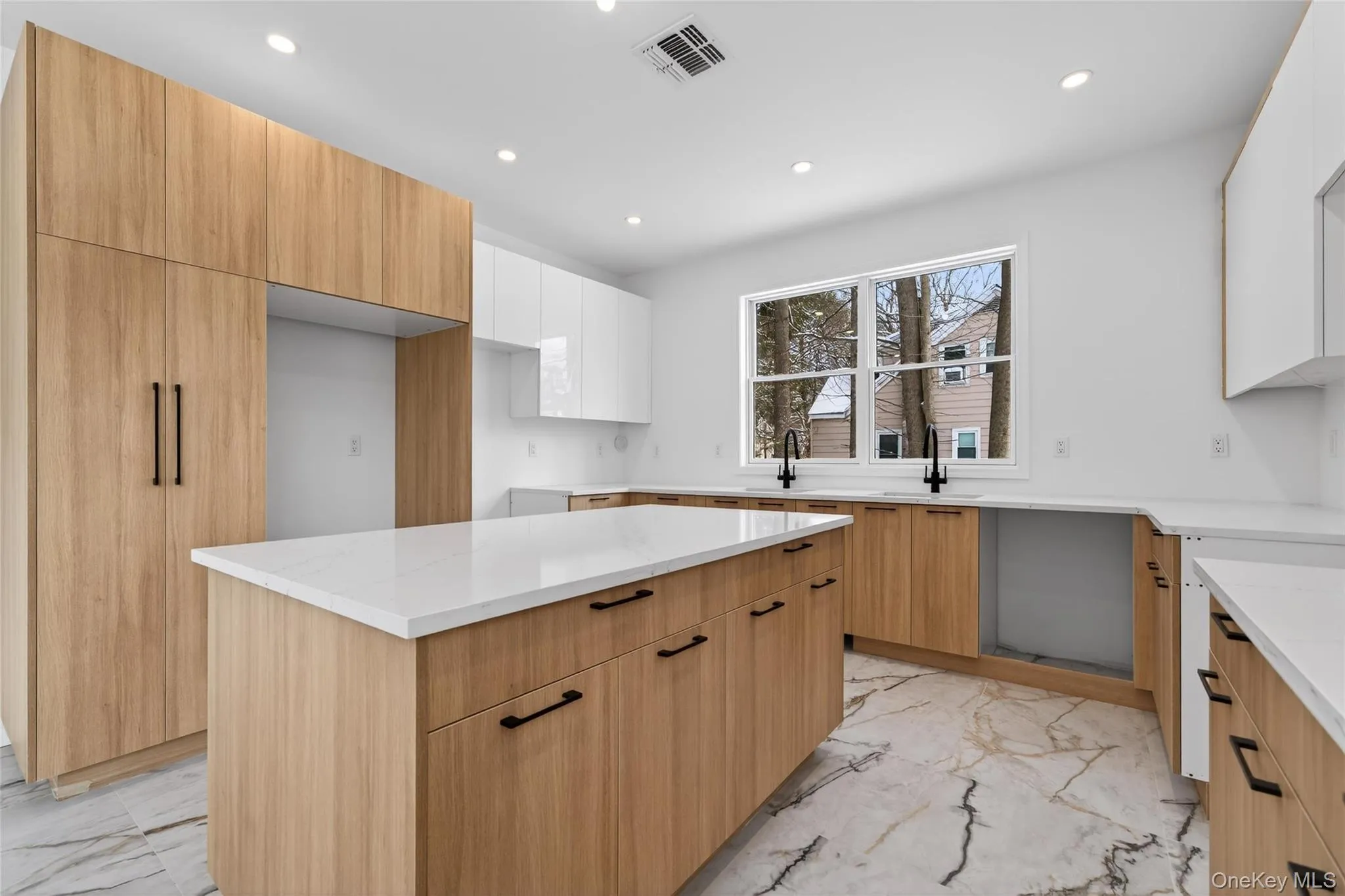 Kitchen featuring light marble finish flooring, modern cabinets, light stone counters, recessed lighting, and a kitchen island Kitchen featuring light marble finish flooring, modern cabinets, light stone counters, recessed lighting, and a kitchen island