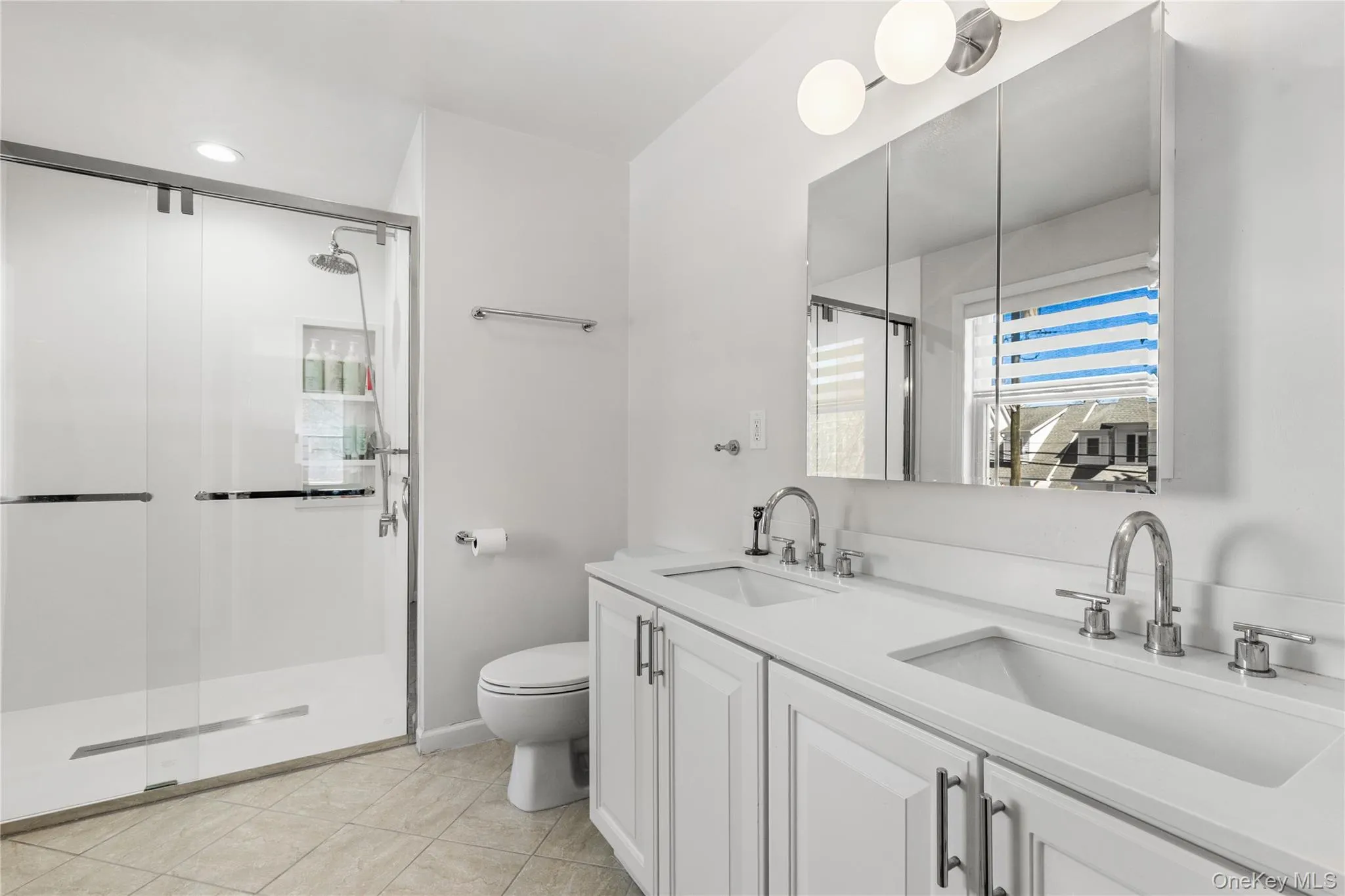 Primary bathroom with double sinks enjoys a newly renovated shower Primary bathroom with double sinks enjoys a newly renovated shower