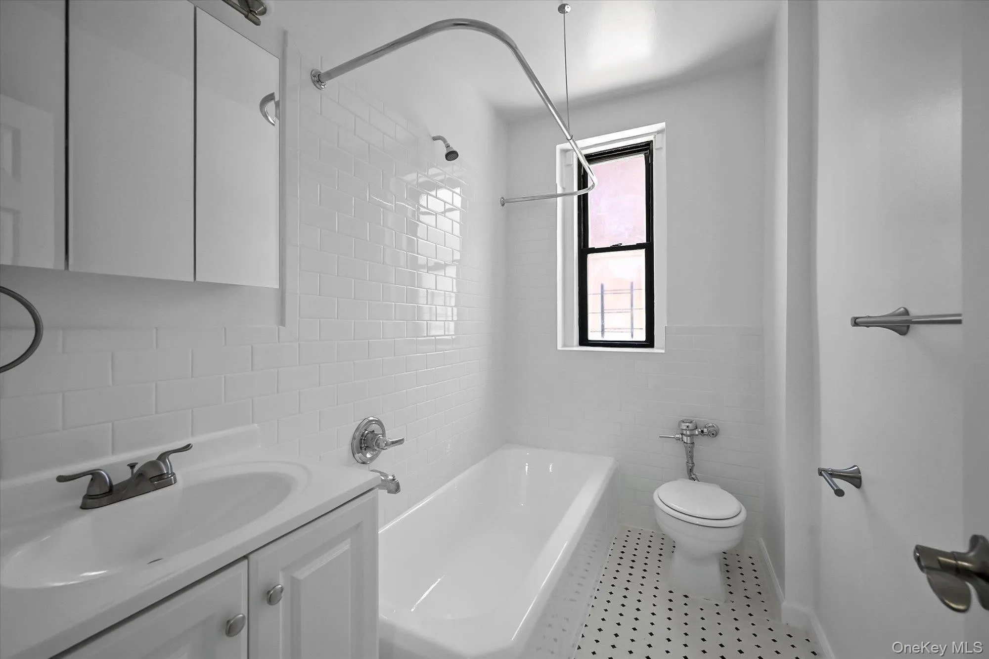 Windowed bathroom featuring vanity, tile walls, and shower / washtub combination. Windowed bathroom featuring vanity, tile walls, and shower / washtub combination.