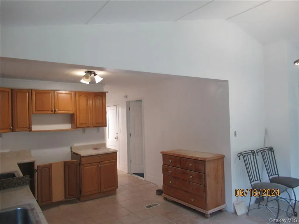 Kitchen featuring lofted ceiling and light tile floors Kitchen featuring lofted ceiling and light tile floors