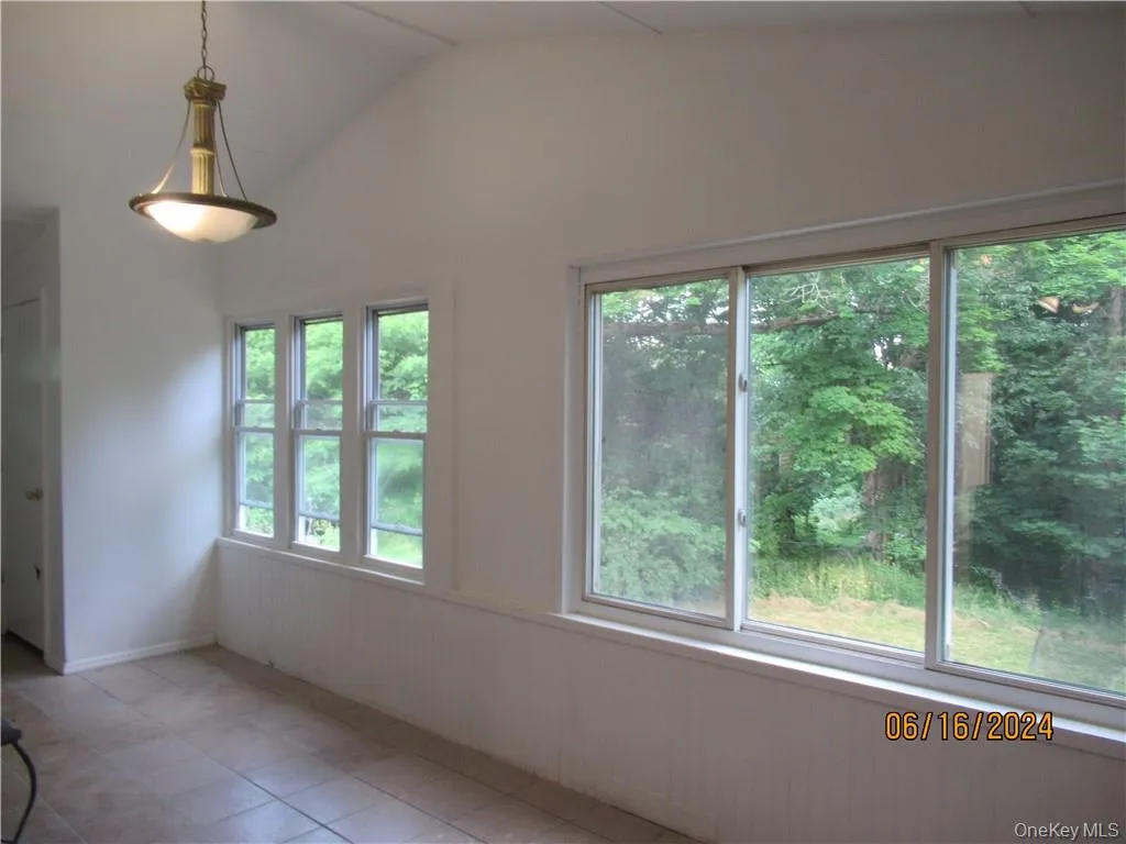 Dining area featuring tile floors and lofted ceiling Dining area featuring tile floors and lofted ceiling