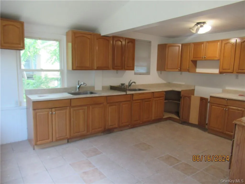 Kitchen featuring sink and light tile floors Kitchen featuring sink and light tile floors