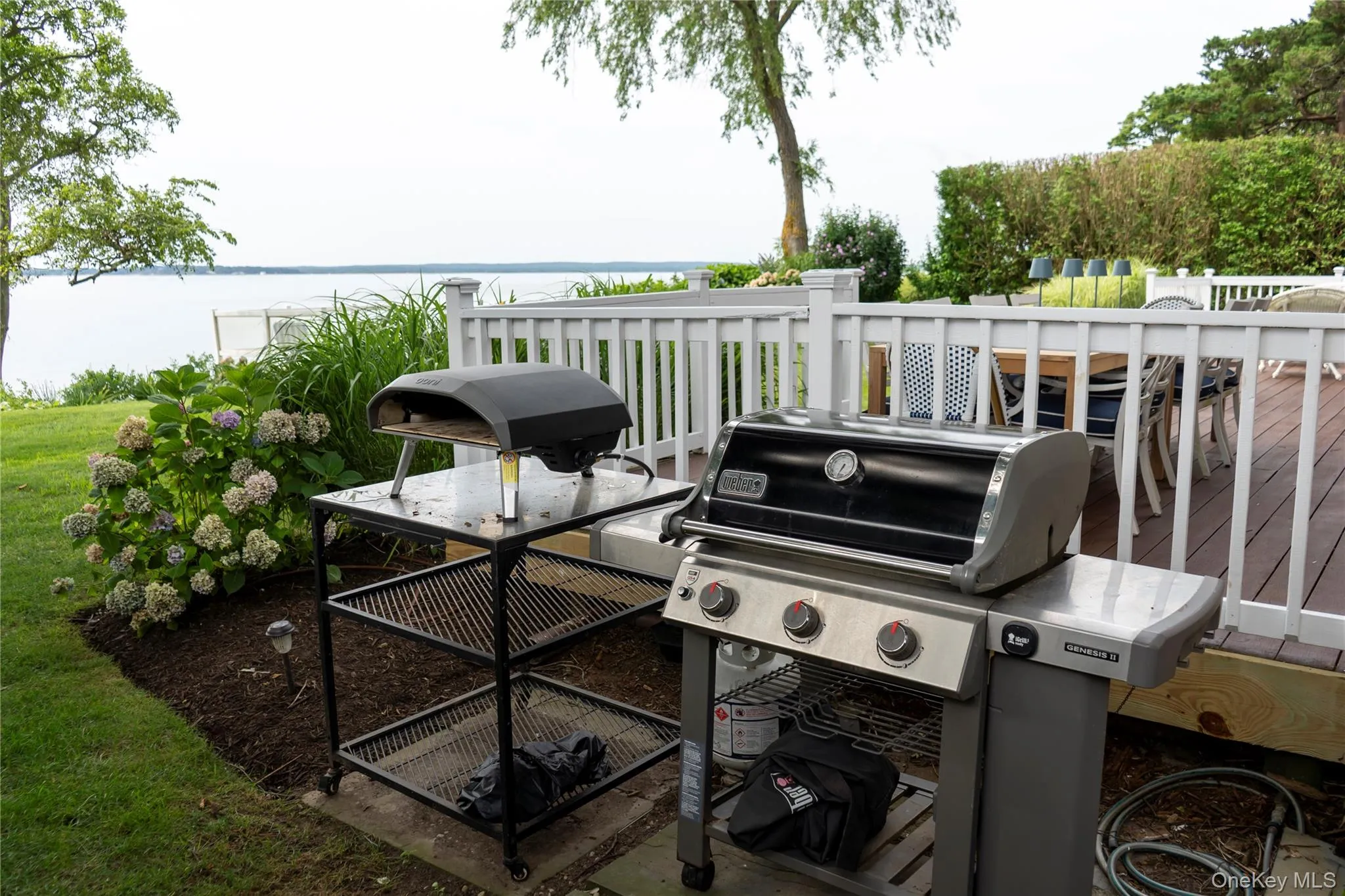 View of patio / terrace featuring grilling area and a deck with water view View of patio / terrace featuring grilling area and a deck with water view