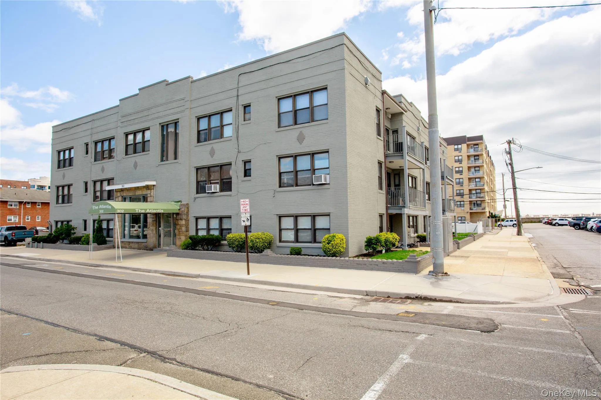 View of building exterior featuring cooling unit and uncovered parking View of building exterior featuring cooling unit and uncovered parking