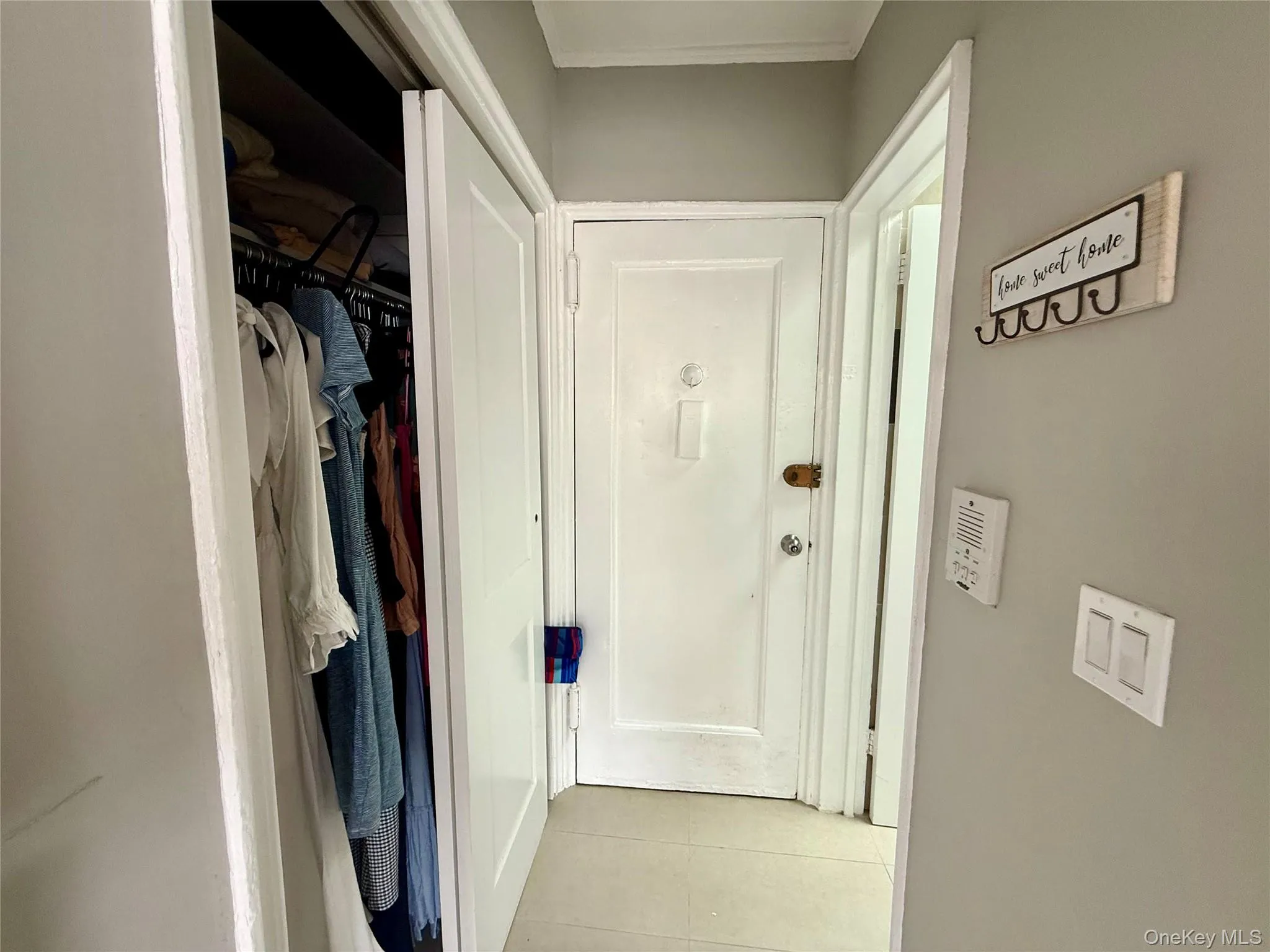 Hallway with light tile patterned floors and ornamental molding Hallway with light tile patterned floors and ornamental molding