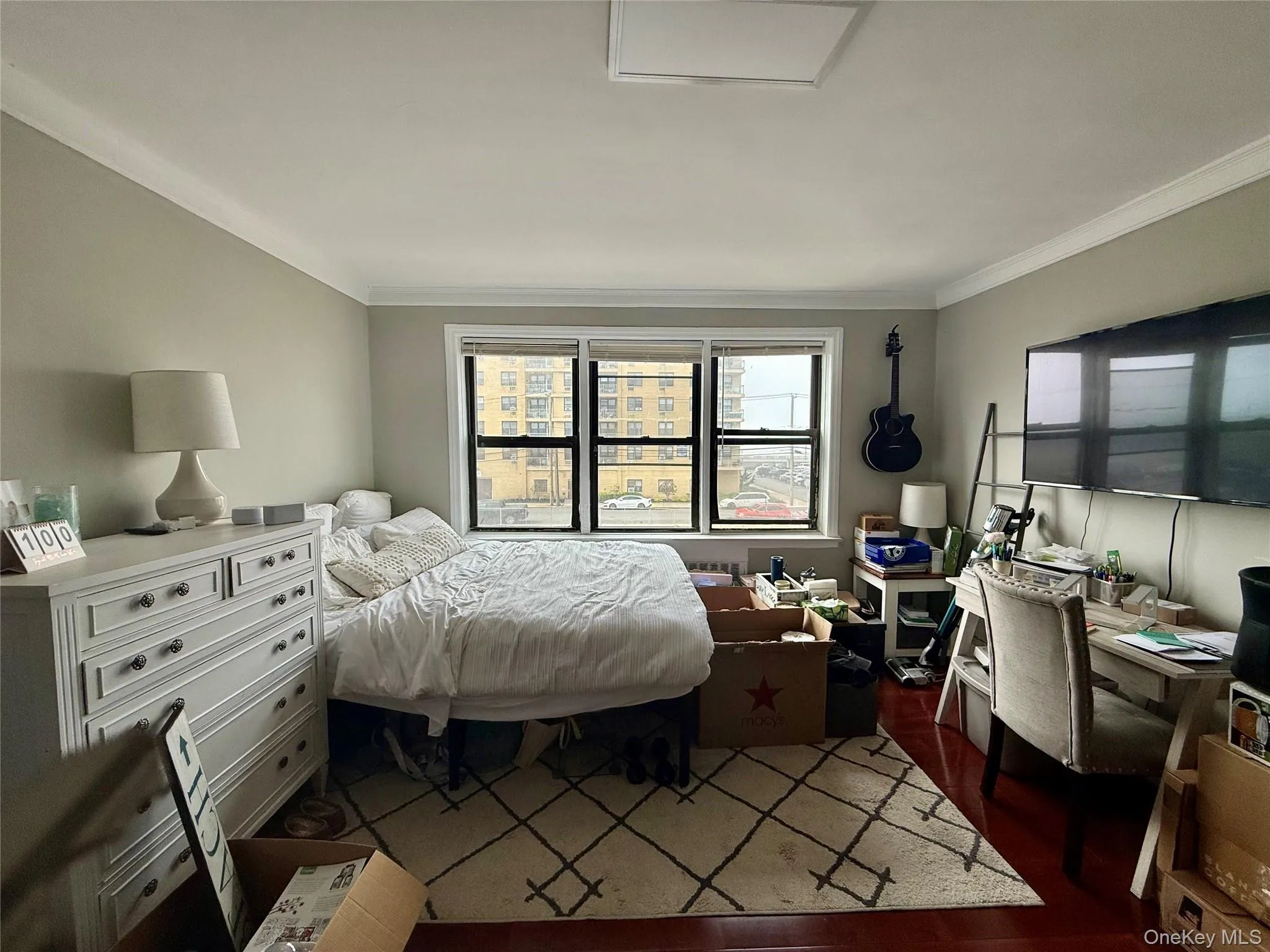 Bedroom featuring crown molding and wood finished floors Bedroom featuring crown molding and wood finished floors