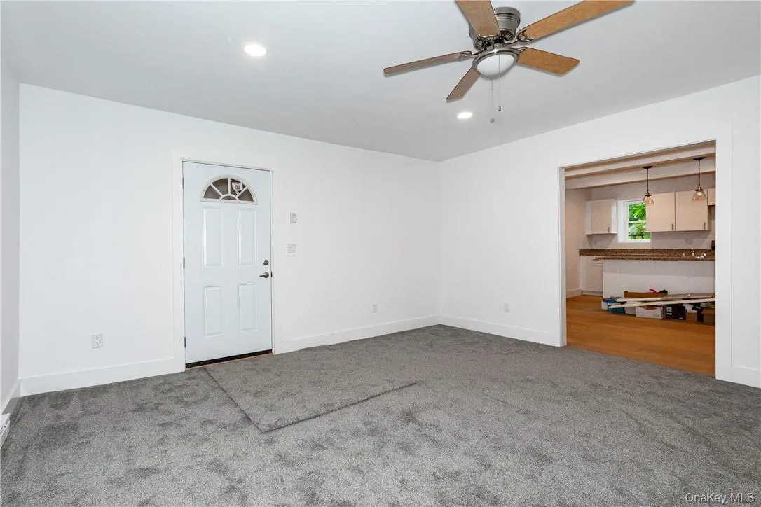 Empty room featuring dark carpet and ceiling fan Empty room featuring dark carpet and ceiling fan