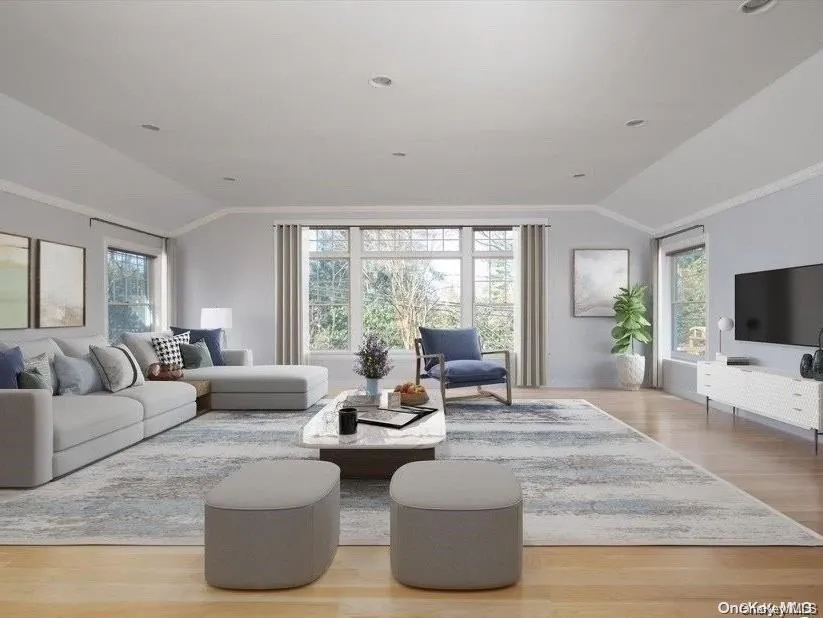 Living area with lofted ceiling and light wood-style flooring Living area with lofted ceiling and light wood-style flooring