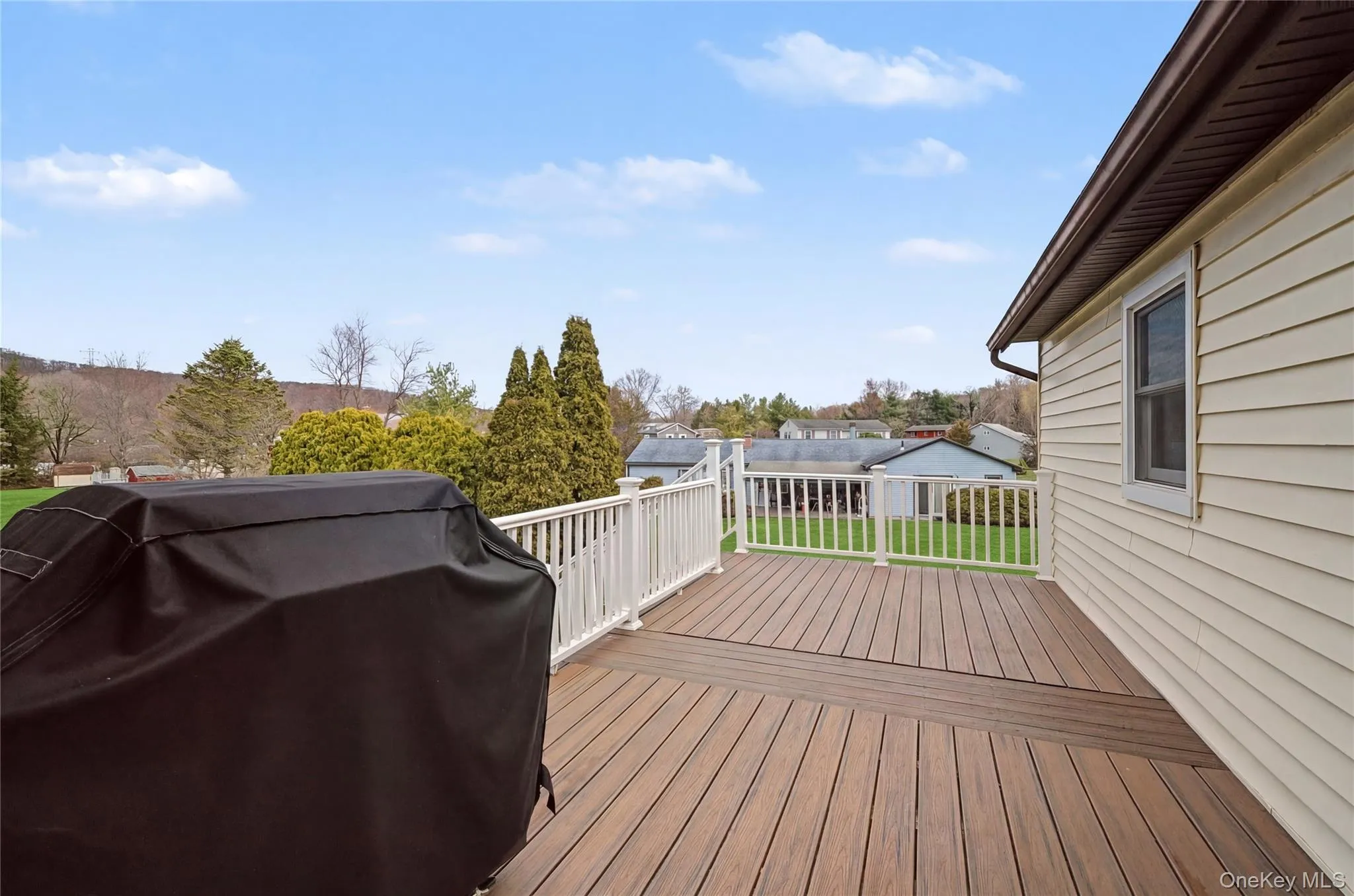 Deck featuring a grill and a lawn Deck featuring a grill and a lawn