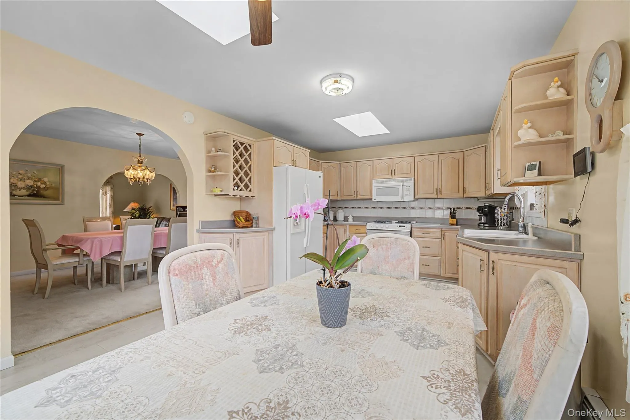 Eat In KItchen area with a skylight, a ceiling fan, a baseboard heating unit, and arched walkways Eat In KItchen area with a skylight, a ceiling fan, a baseboard heating unit, and arched walkways