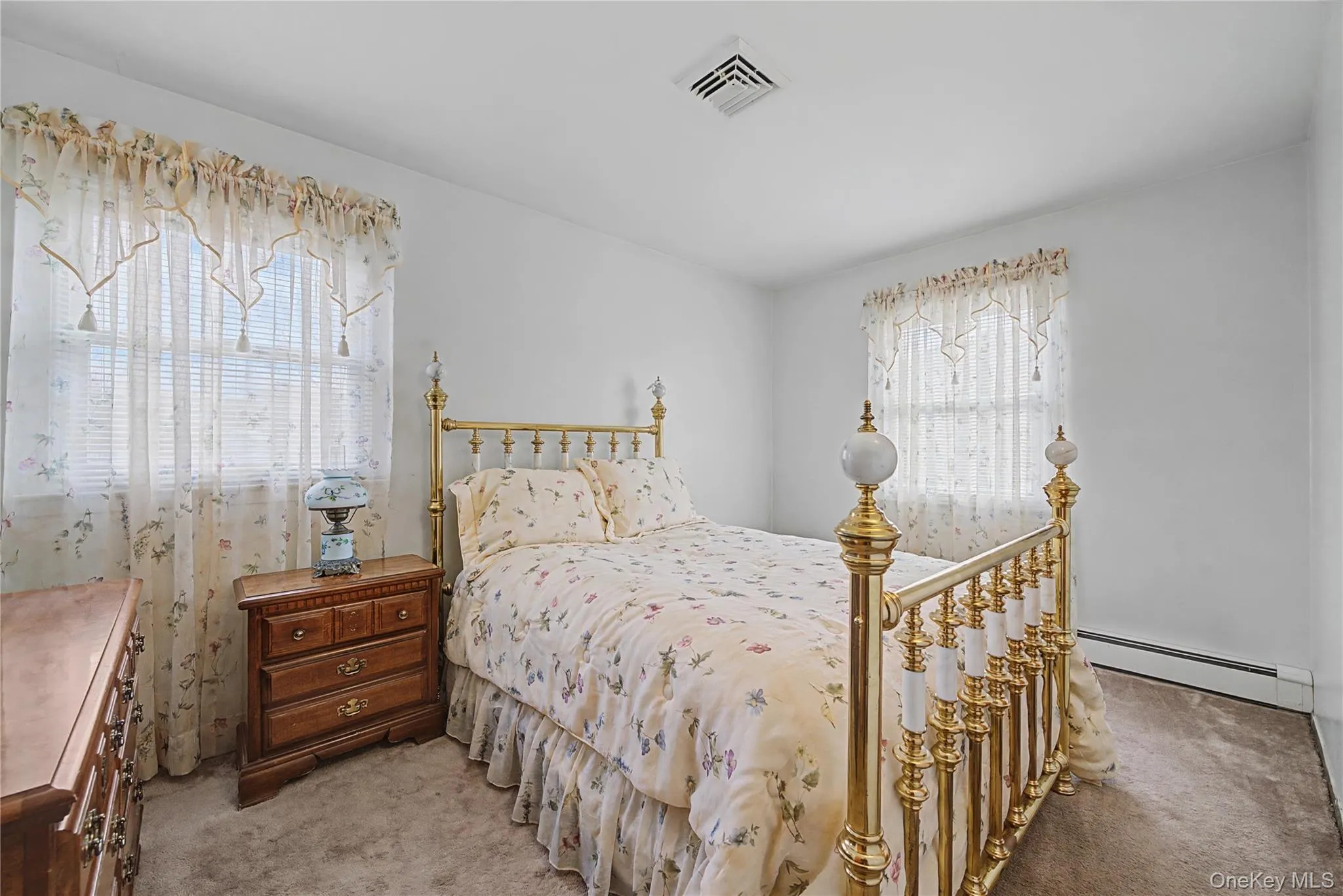 Bedroom featuring baseboard heating and light carpet Bedroom featuring baseboard heating and light carpet
