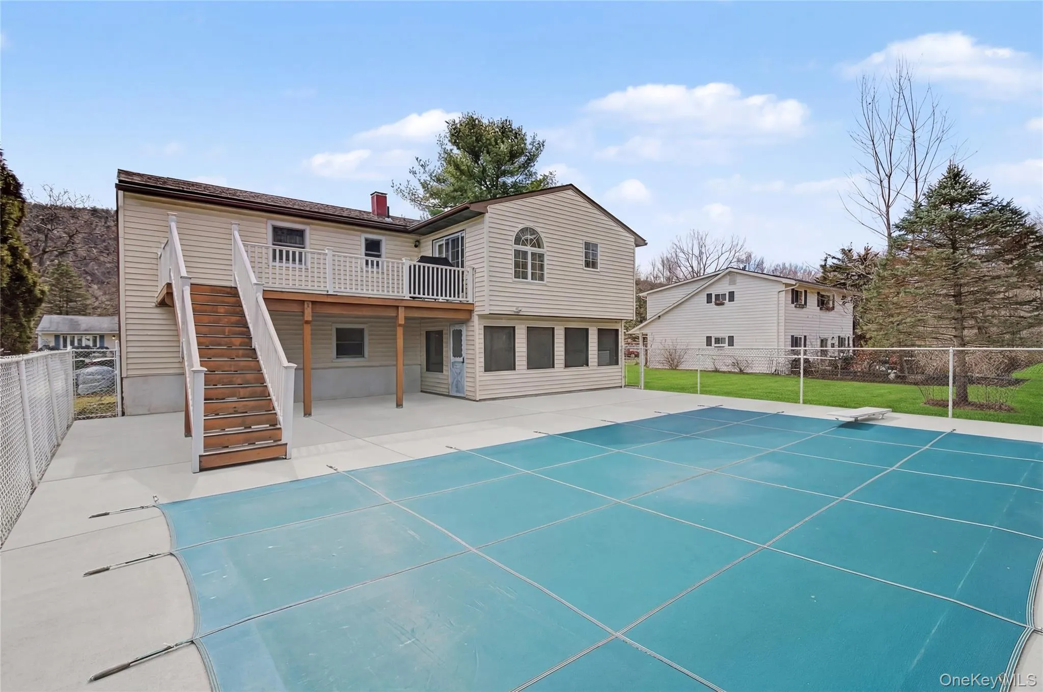 Rear view of property featuring patio, deck and the pool. Rear view of property featuring patio, deck and the pool.