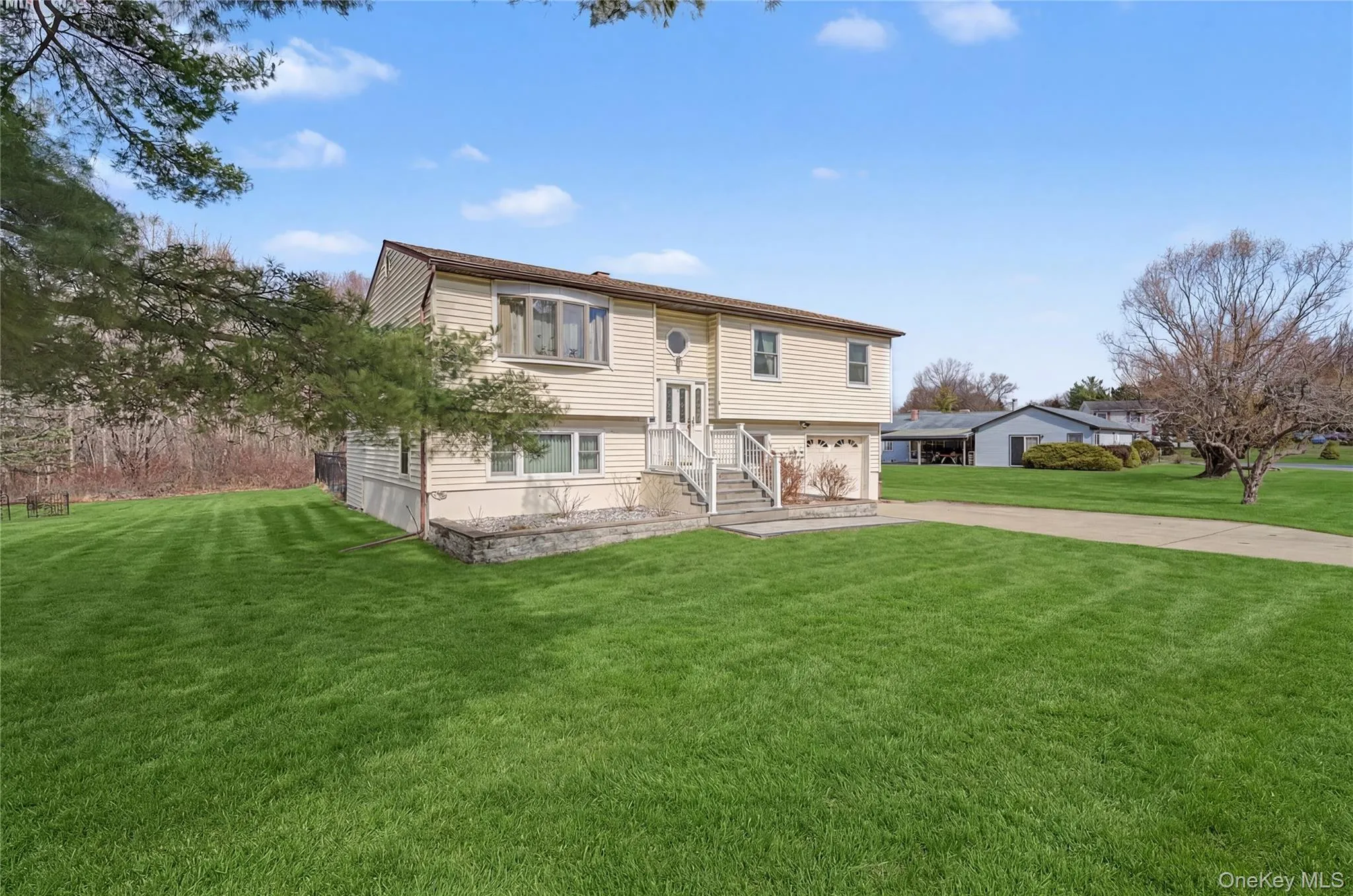 Side of property with a yard, driveway, and an attached garage Side of property with a yard, driveway, and an attached garage