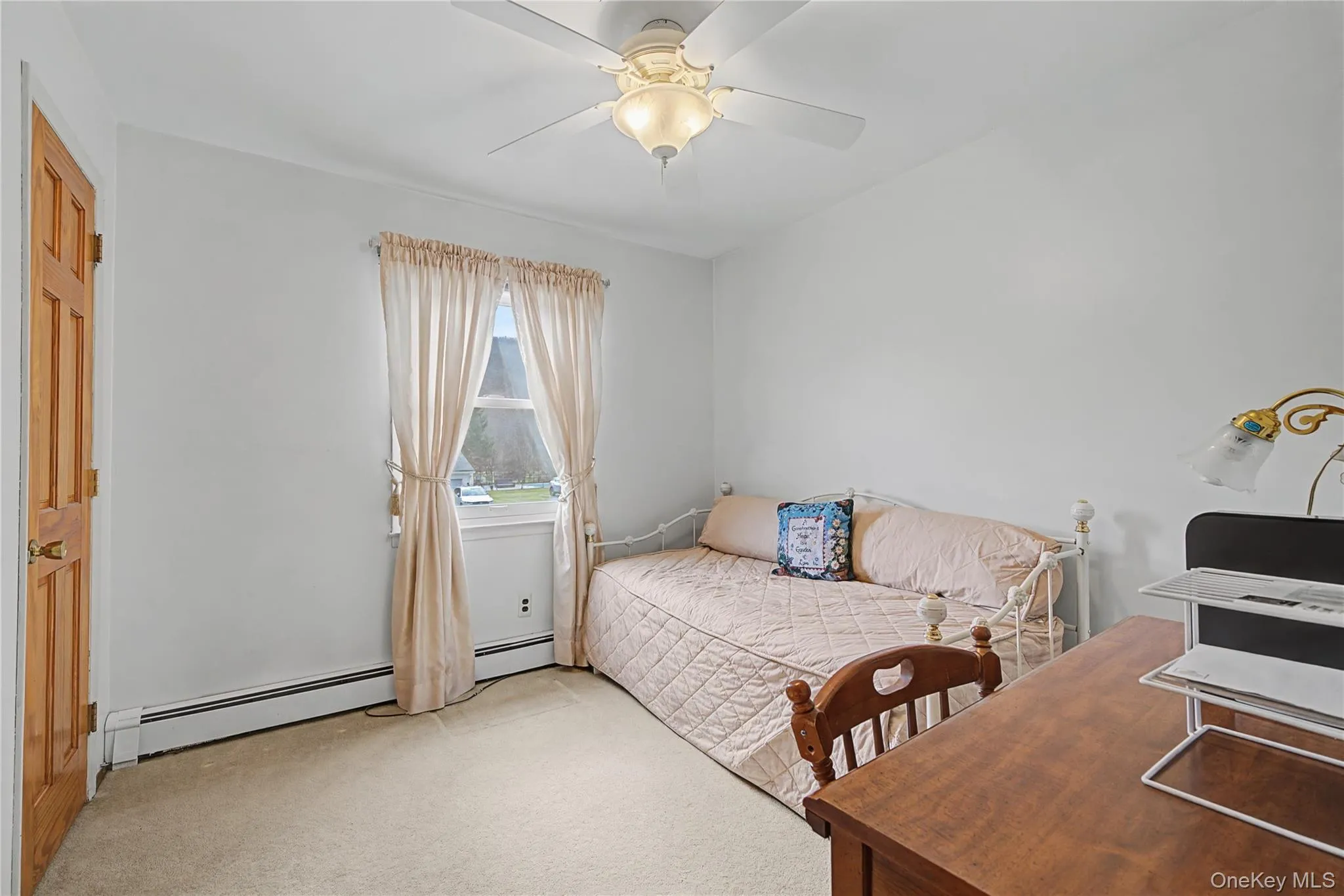 Carpeted bedroom featuring a baseboard radiator and a ceiling fan Carpeted bedroom featuring a baseboard radiator and a ceiling fan