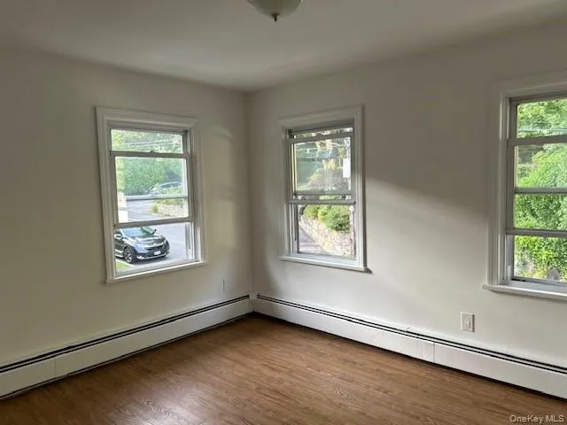 Empty room featuring dark hardwood / wood-style floors and a wealth of natural light Empty room featuring dark hardwood / wood-style floors and a wealth of natural light