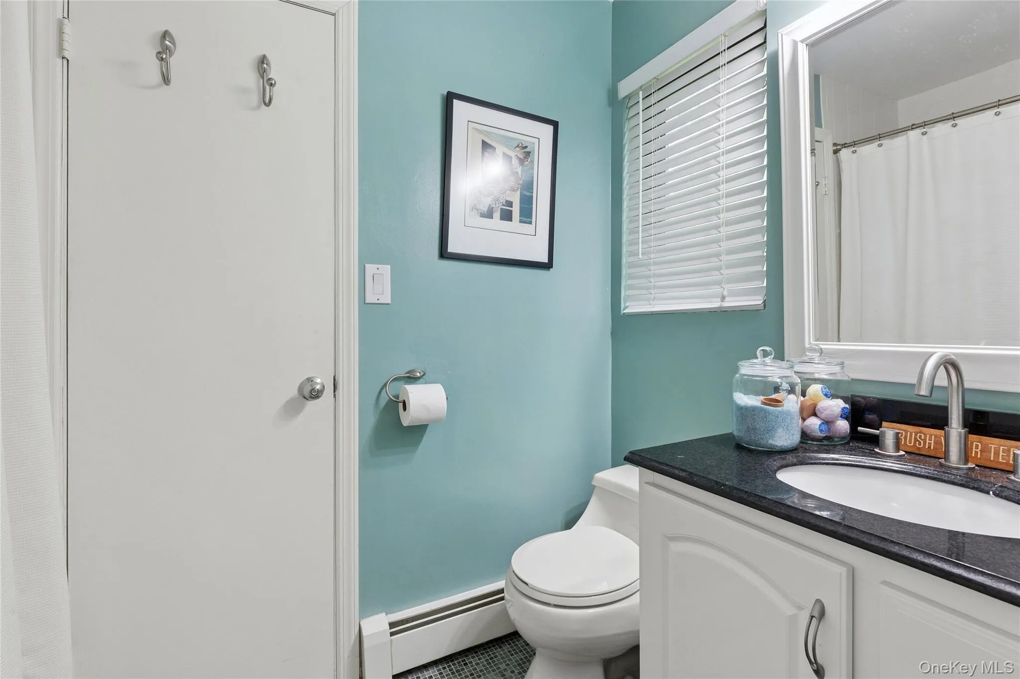 Bathroom with a baseboard heating unit, vanity, and toilet Bathroom with a baseboard heating unit, vanity, and toilet