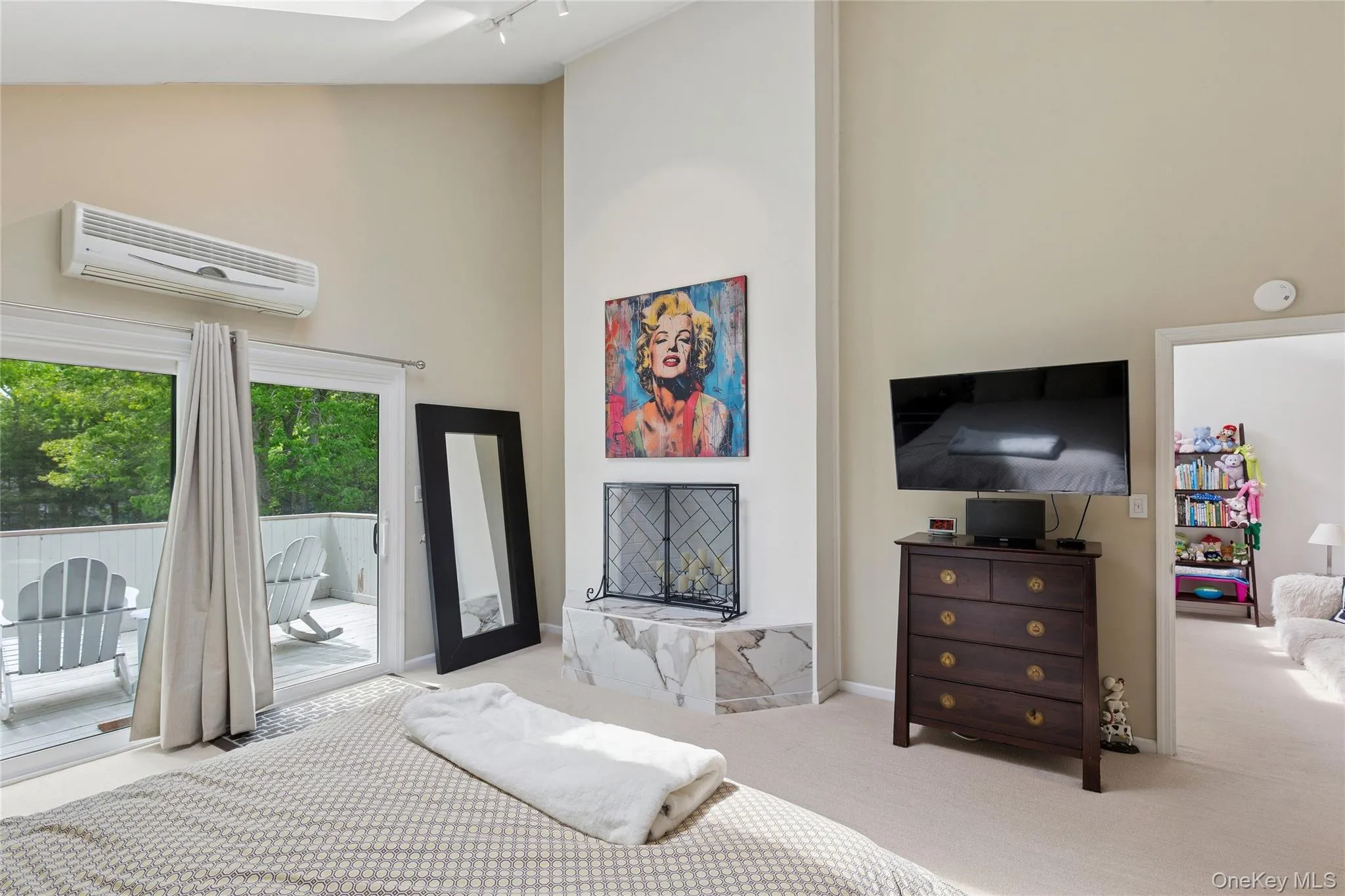 Bedroom with a wall unit AC, access to outside, carpet, high vaulted ceiling, and track lighting Bedroom with a wall unit AC, access to outside, carpet, high vaulted ceiling, and track lighting