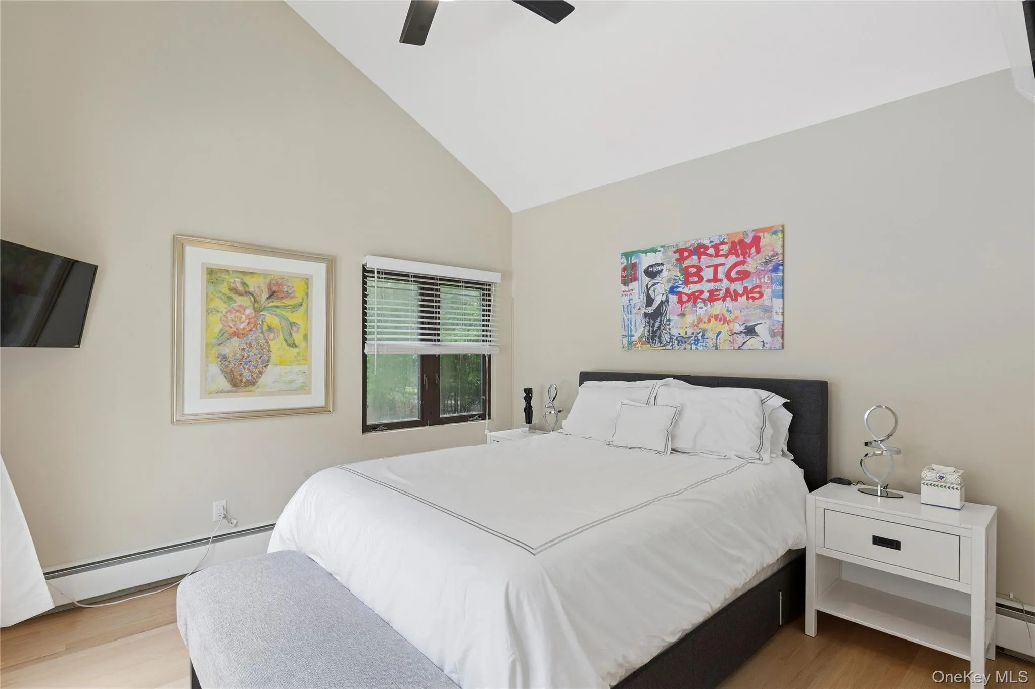 Bedroom featuring a baseboard radiator, high vaulted ceiling, wood finished floors, and a ceiling fan Bedroom featuring a baseboard radiator, high vaulted ceiling, wood finished floors, and a ceiling fan