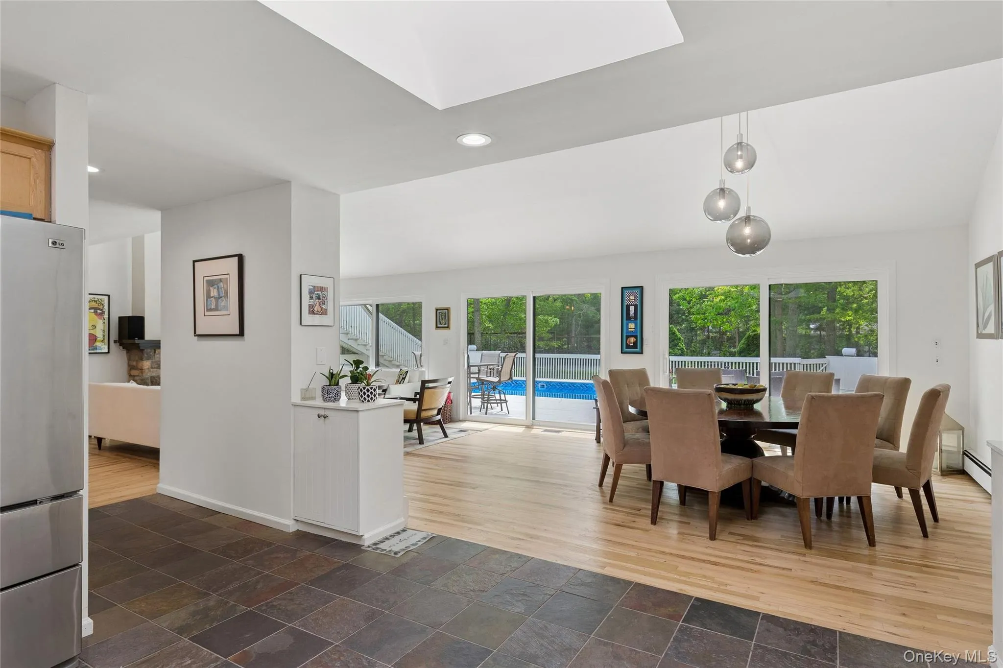 Dining space with recessed lighting, stone tile flooring, baseboards, and a skylight Dining space with recessed lighting, stone tile flooring, baseboards, and a skylight