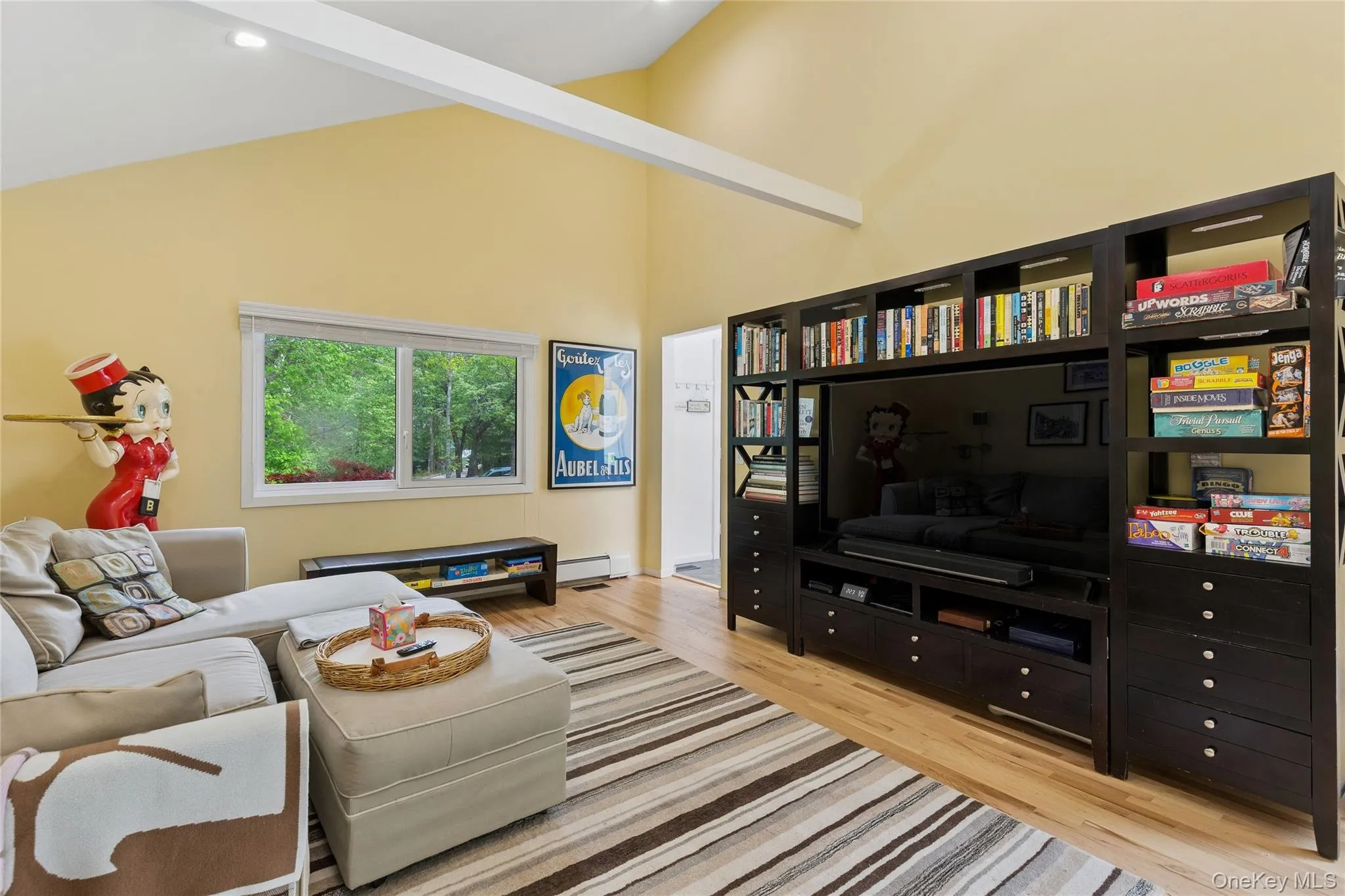 Living room with wood finished floors, high vaulted ceiling, and a baseboard radiator Living room with wood finished floors, high vaulted ceiling, and a baseboard radiator