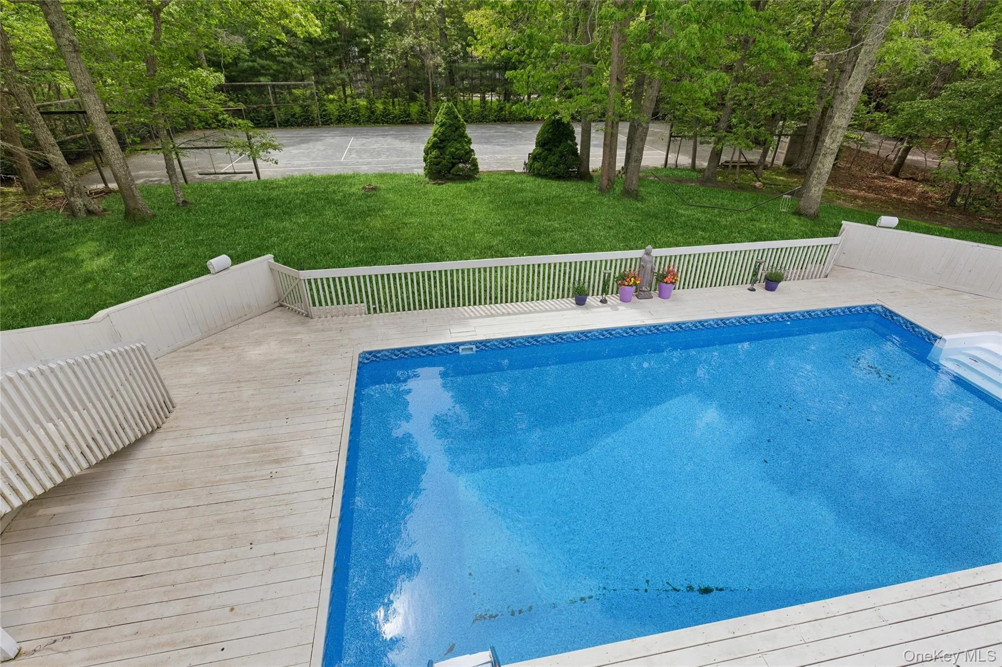 Swimming pool with a yard and a wooden deck Swimming pool with a yard and a wooden deck