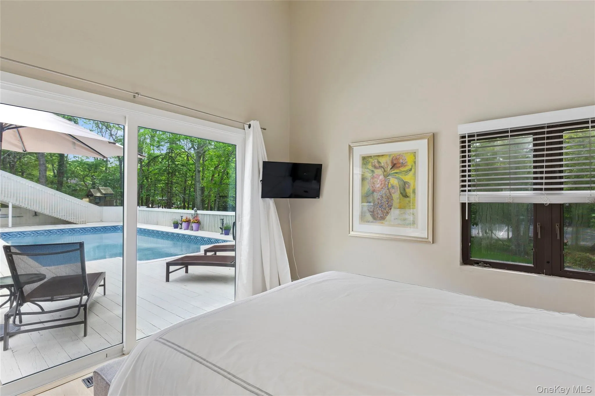 Bedroom featuring access to outside and a high ceiling Bedroom featuring access to outside and a high ceiling