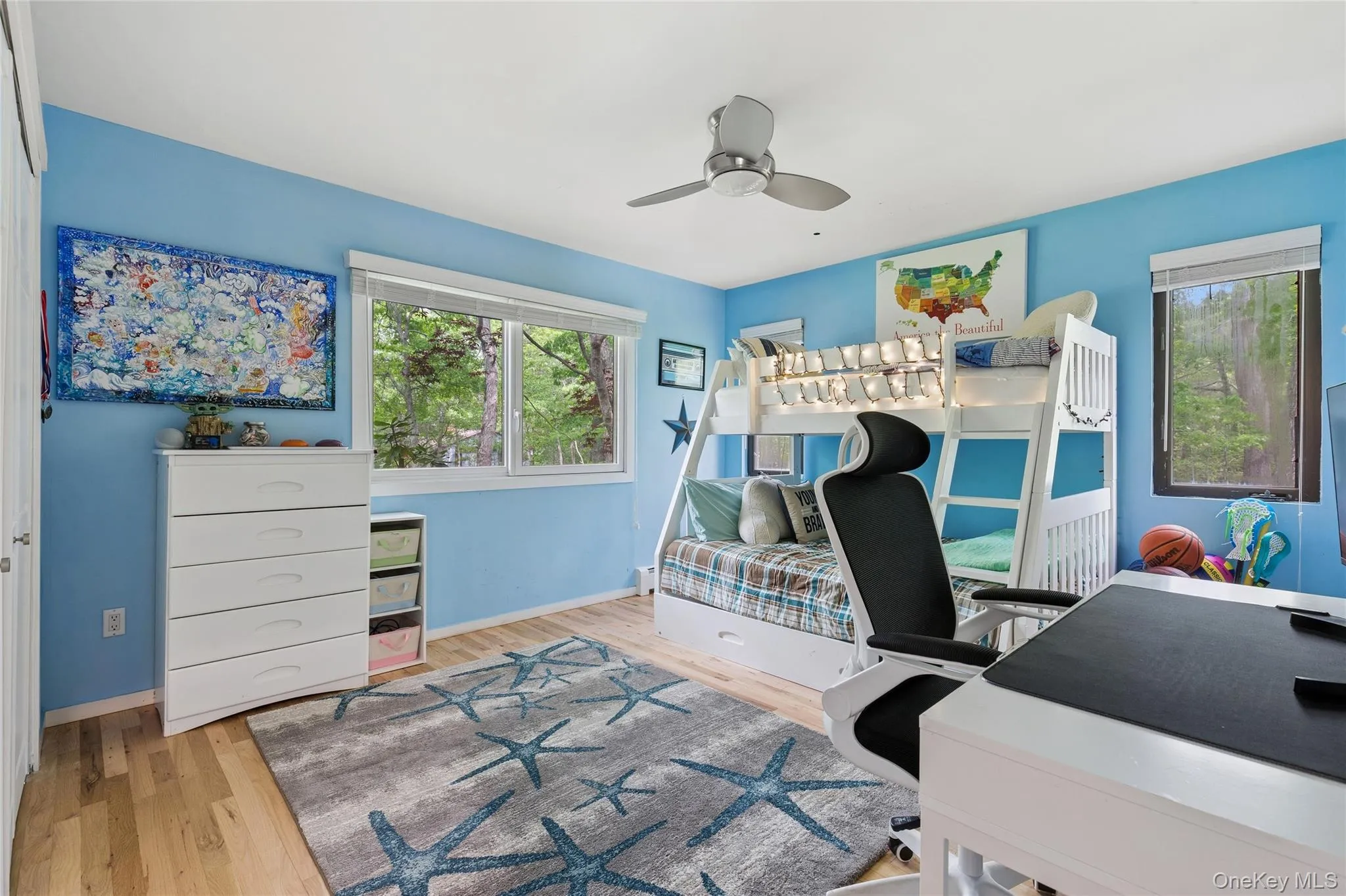 Bedroom with wood finished floors, baseboards, an office area, and a ceiling fan Bedroom with wood finished floors, baseboards, an office area, and a ceiling fan